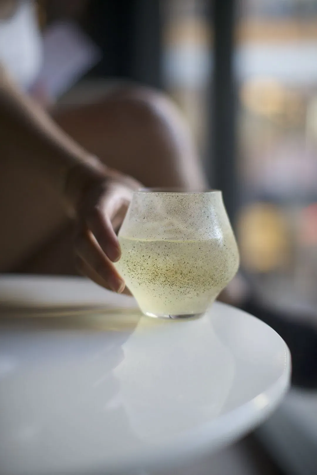 A person holding a wine glass on a table