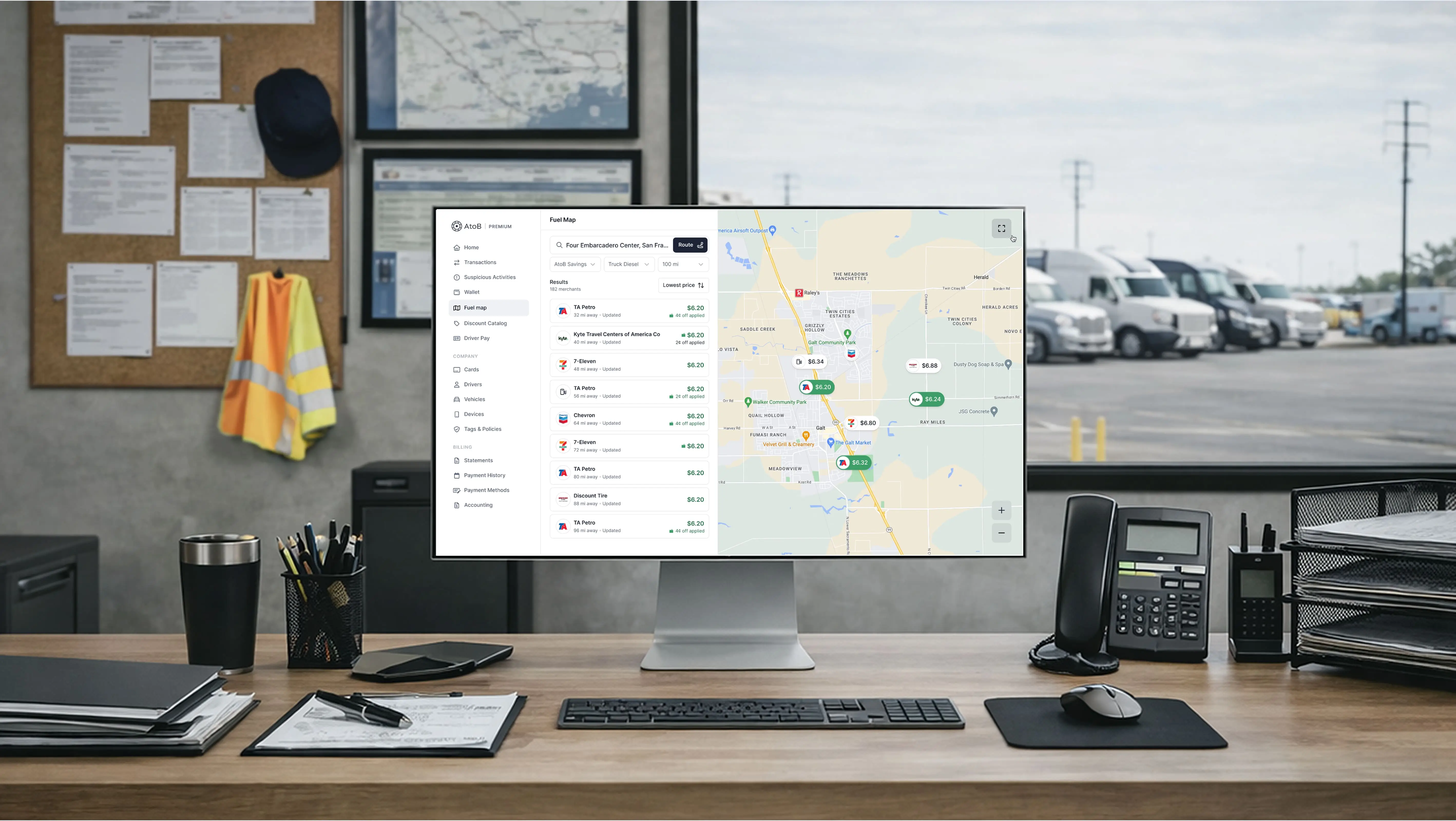 Mockup de l'interface AtoB affichée sur un écran dans un bureau de transport, avec une carte interactive de stations carburant et un tableau de bord de gestion visible