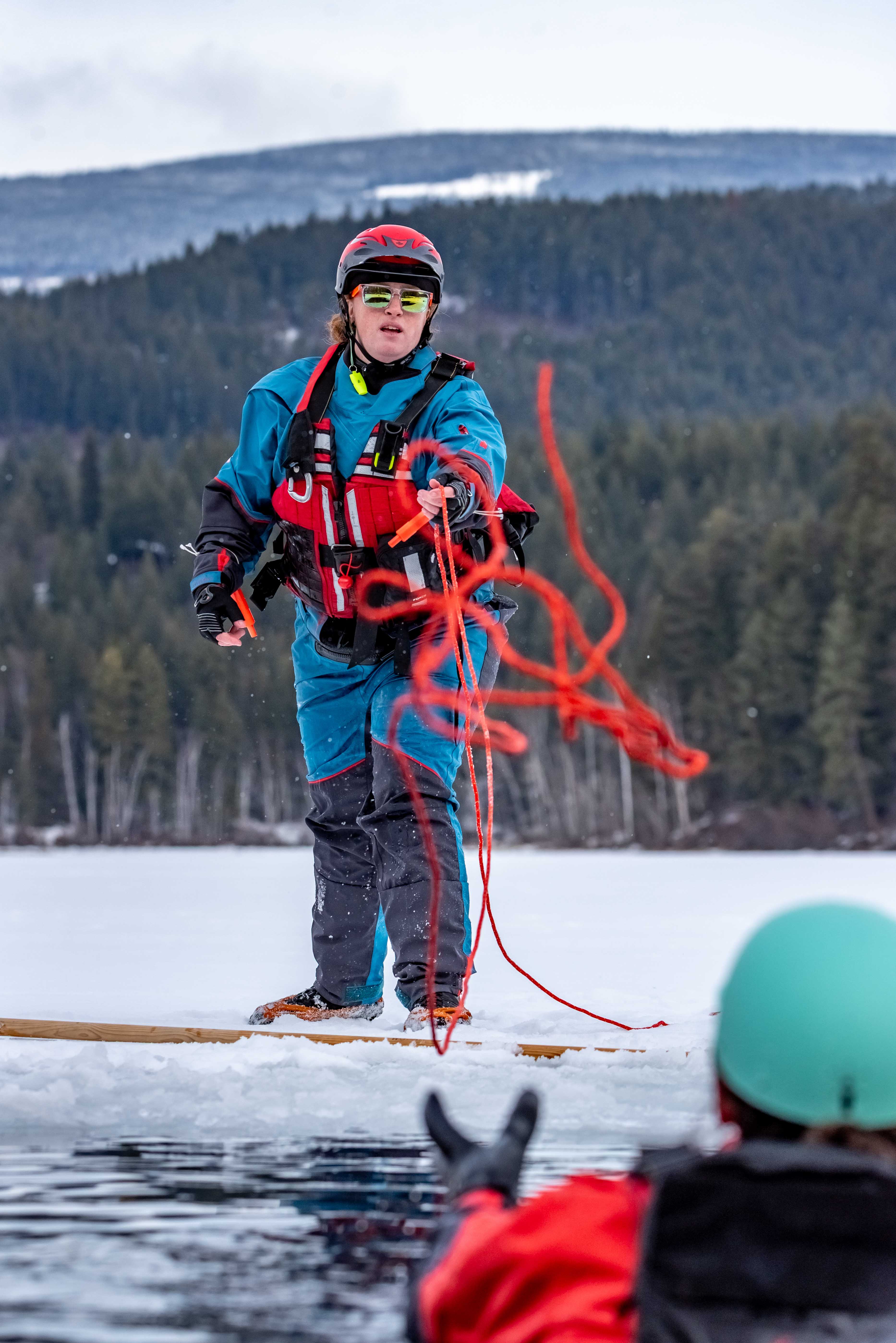 Smiling course participant wearing a helmet with a camera during outdoor rescue training