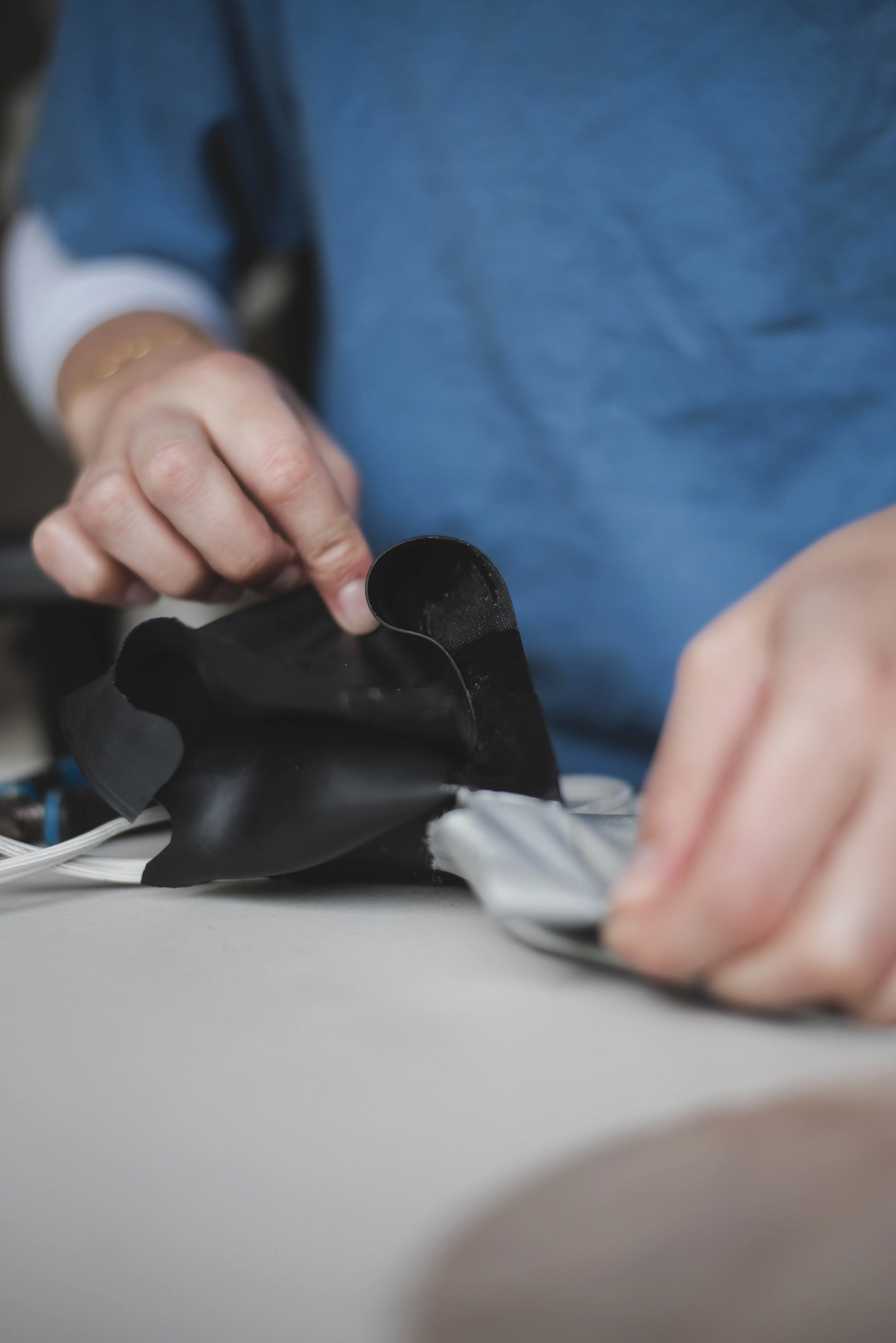 Technician fitting a black latex gasket during drysuit repair