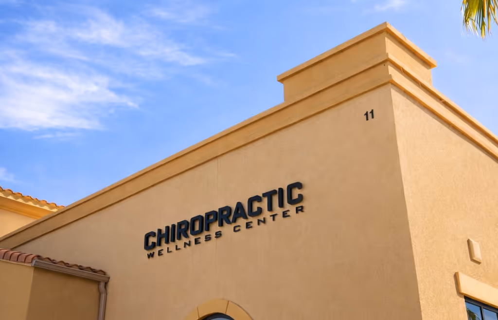 Exterior of a beige building with a sign reading Chiropractic Wellness Center under blue sky. Foresight Wellness Center exterior. Gilbert, AZ