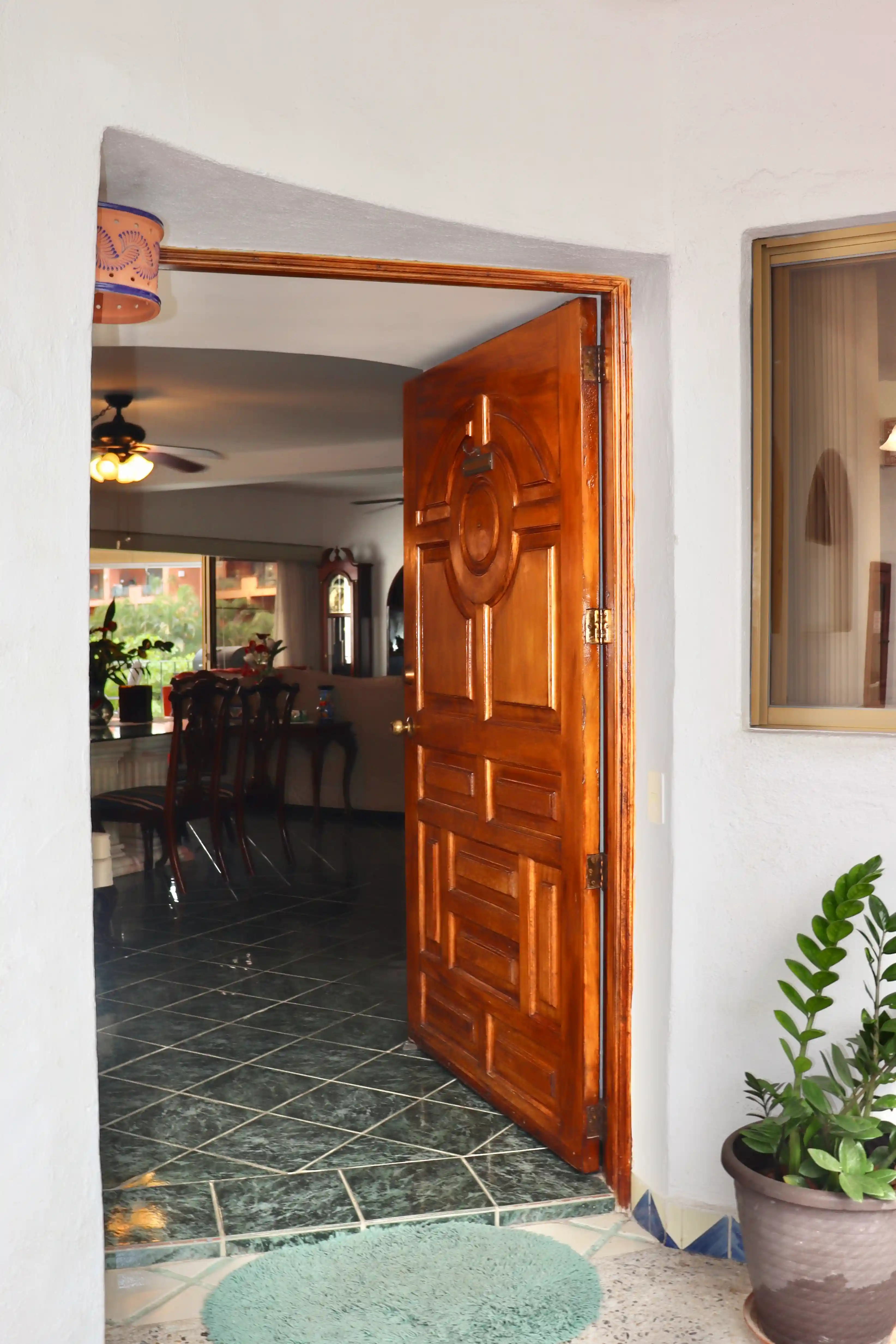Interior perspective from the entrance of Royal Pacific 2304, showing the hallway transition to the dining room with traditional ceiling details and warm ambient lighting.