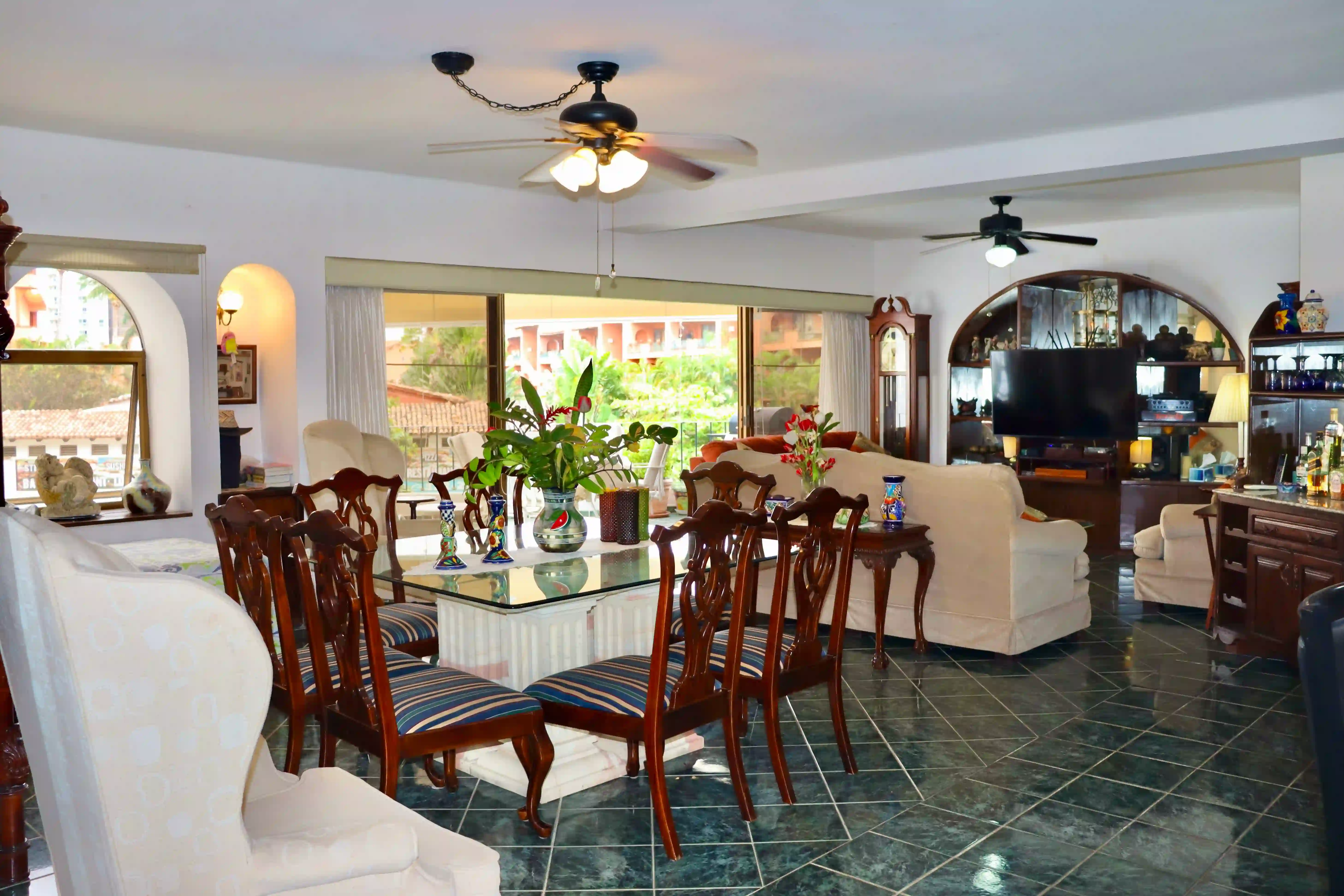 Spacious open-concept living and dining area in Royal Pacific 2304, featuring traditional Mexican furniture, polished marble floors, and large windows with garden views.