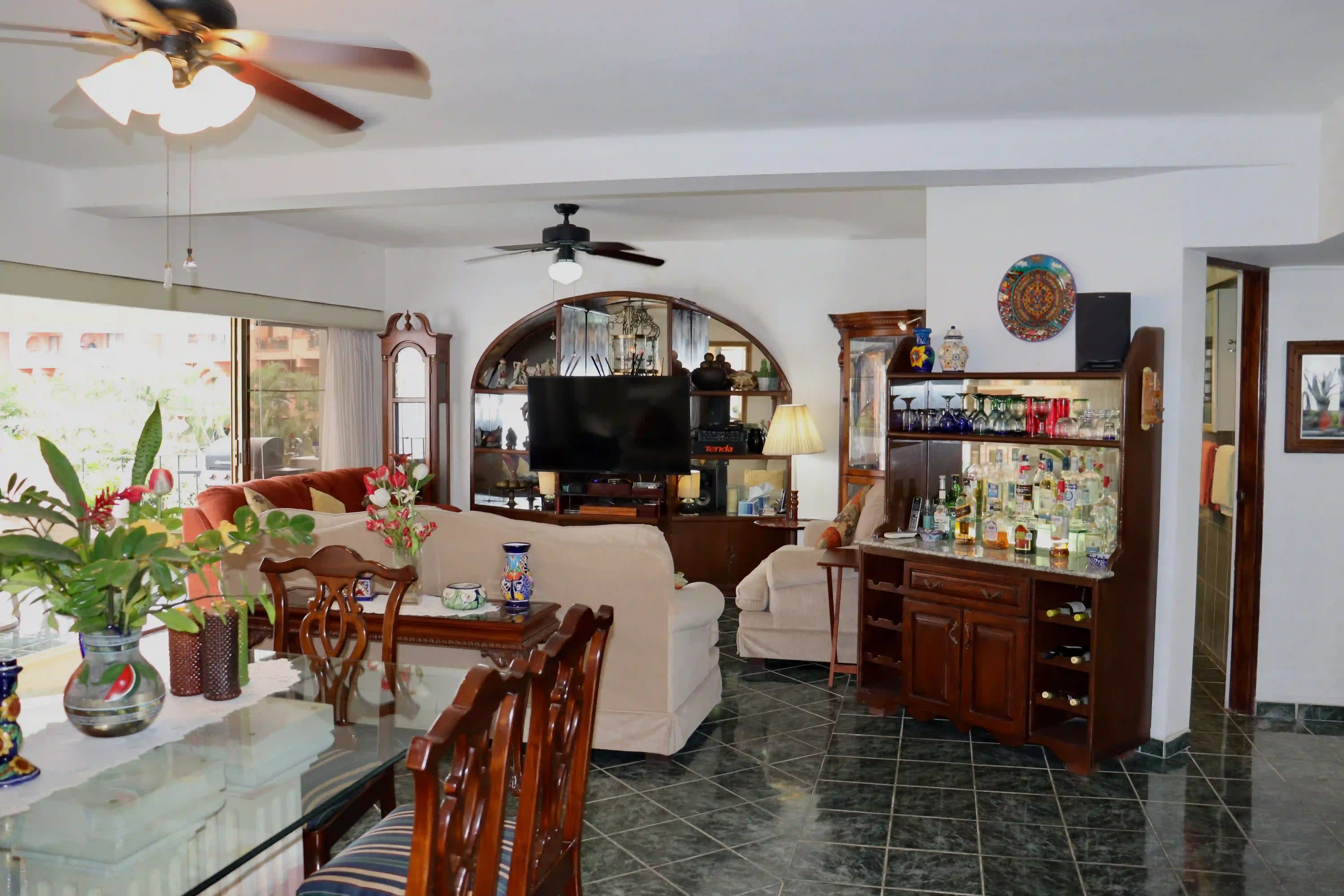 Bright and airy living room at Royal Pacific 2304, featuring large sliding glass doors that lead to a private balcony with tropical views in Marina Vallarta.