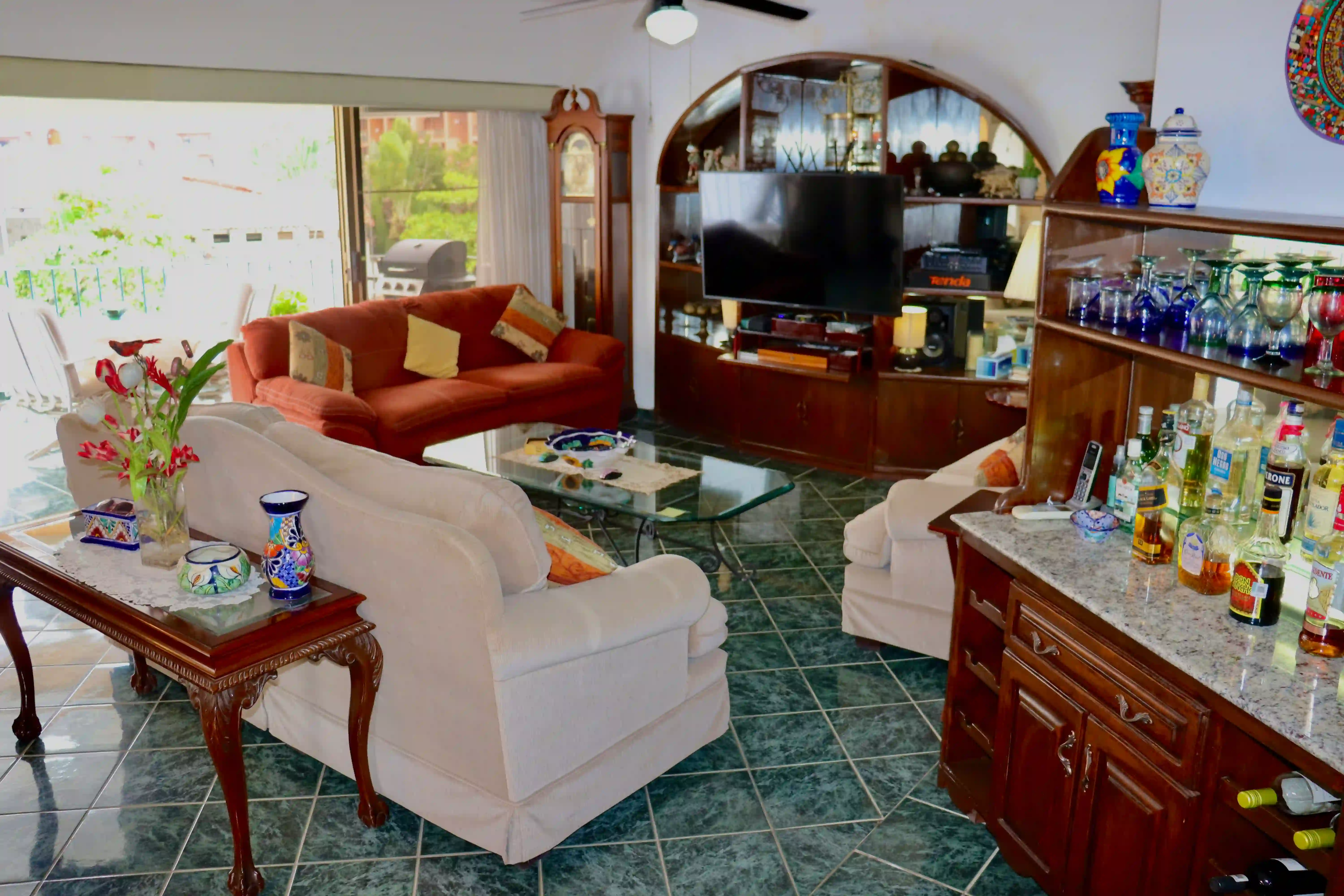 Cozy living area at Royal Pacific 2304 featuring comfortable seating, traditional Mexican wooden furniture, and a flat-screen TV setup for relaxation.