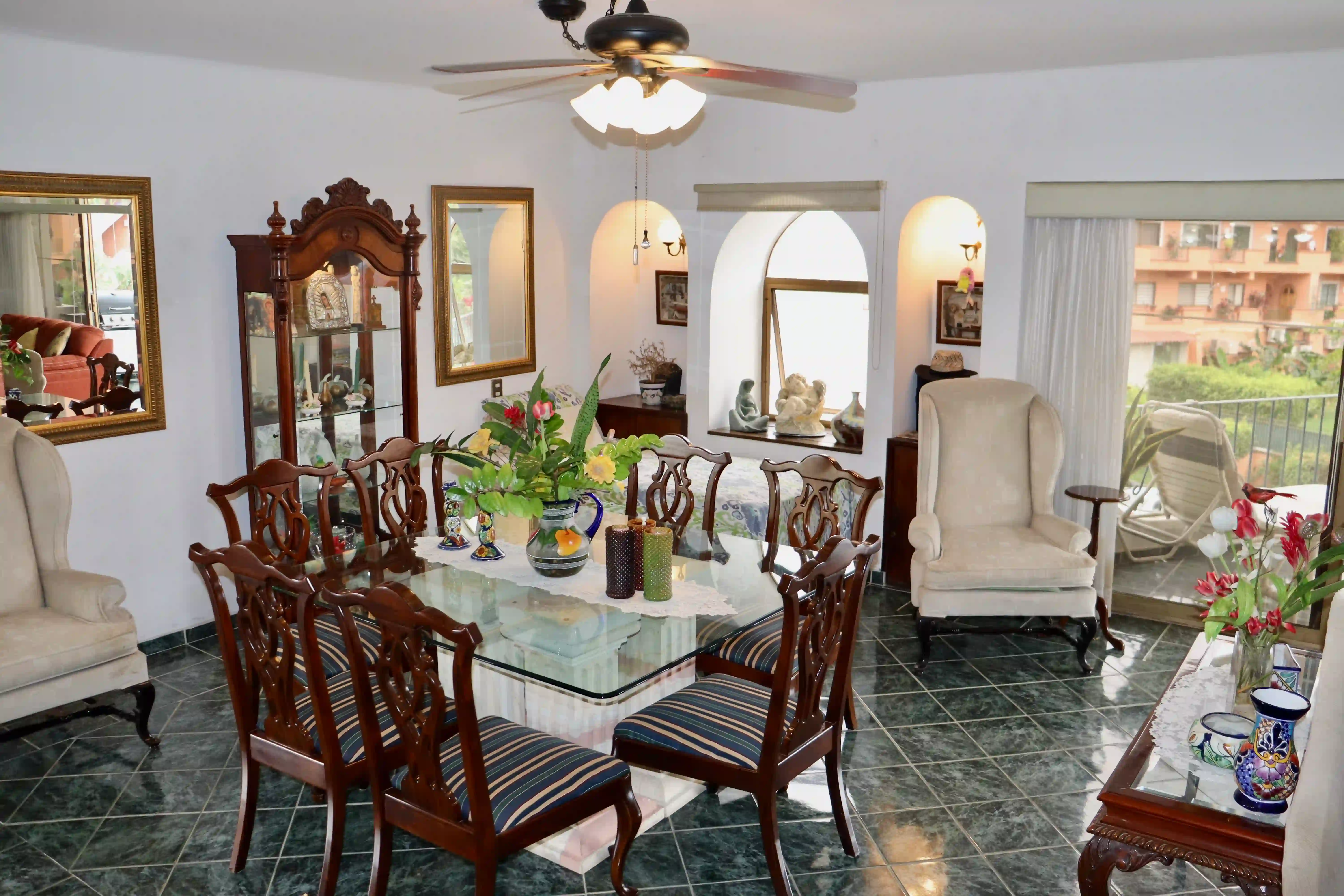 Interior view of the living room showcasing a large, comfortable white sofa and traditional dark wood coffee table, highlighting the sophisticated Mexican decor.