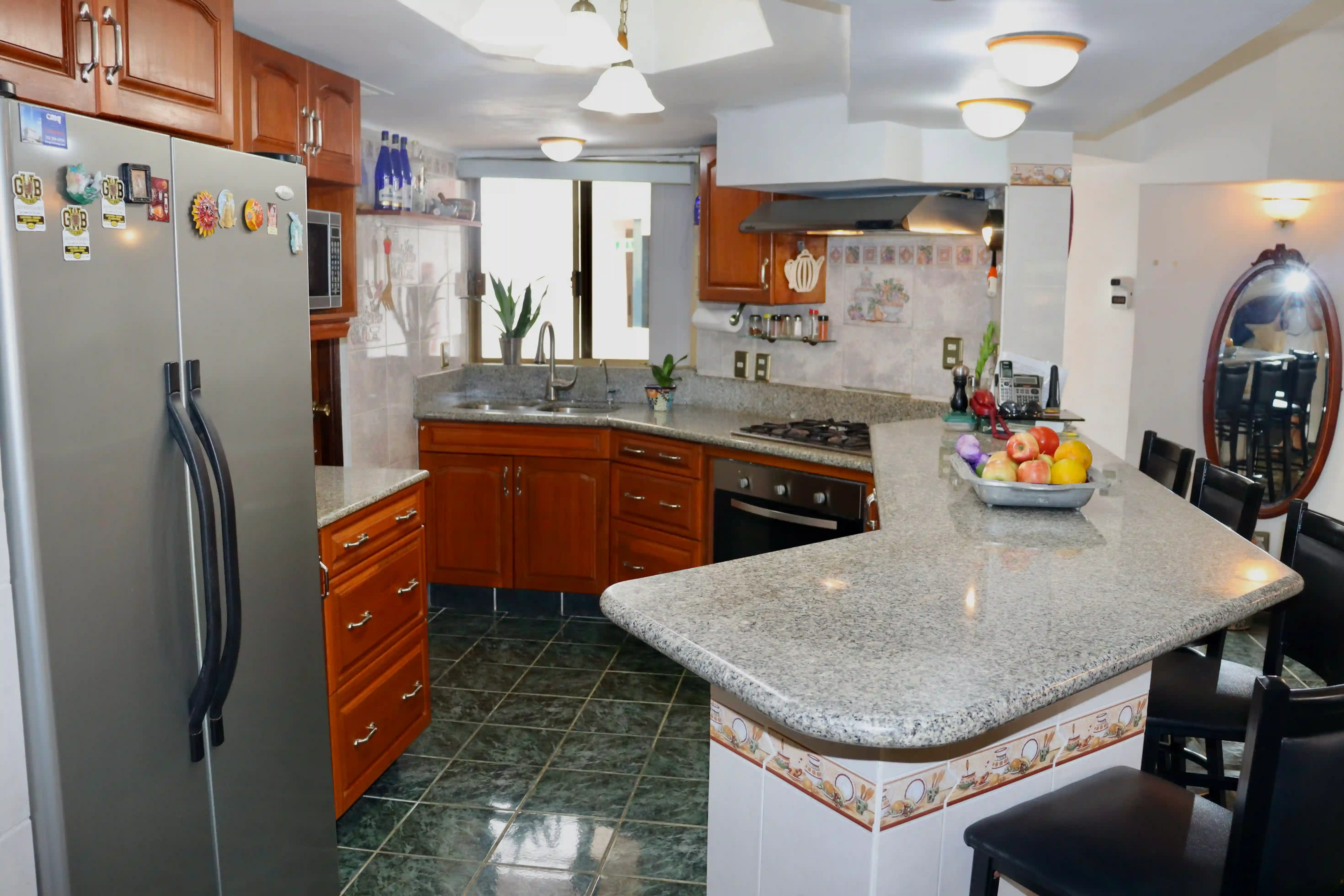 Perspective of the kitchen area highlighting the traditional tilework, ample counter space, and the open-concept connection to the dining area.