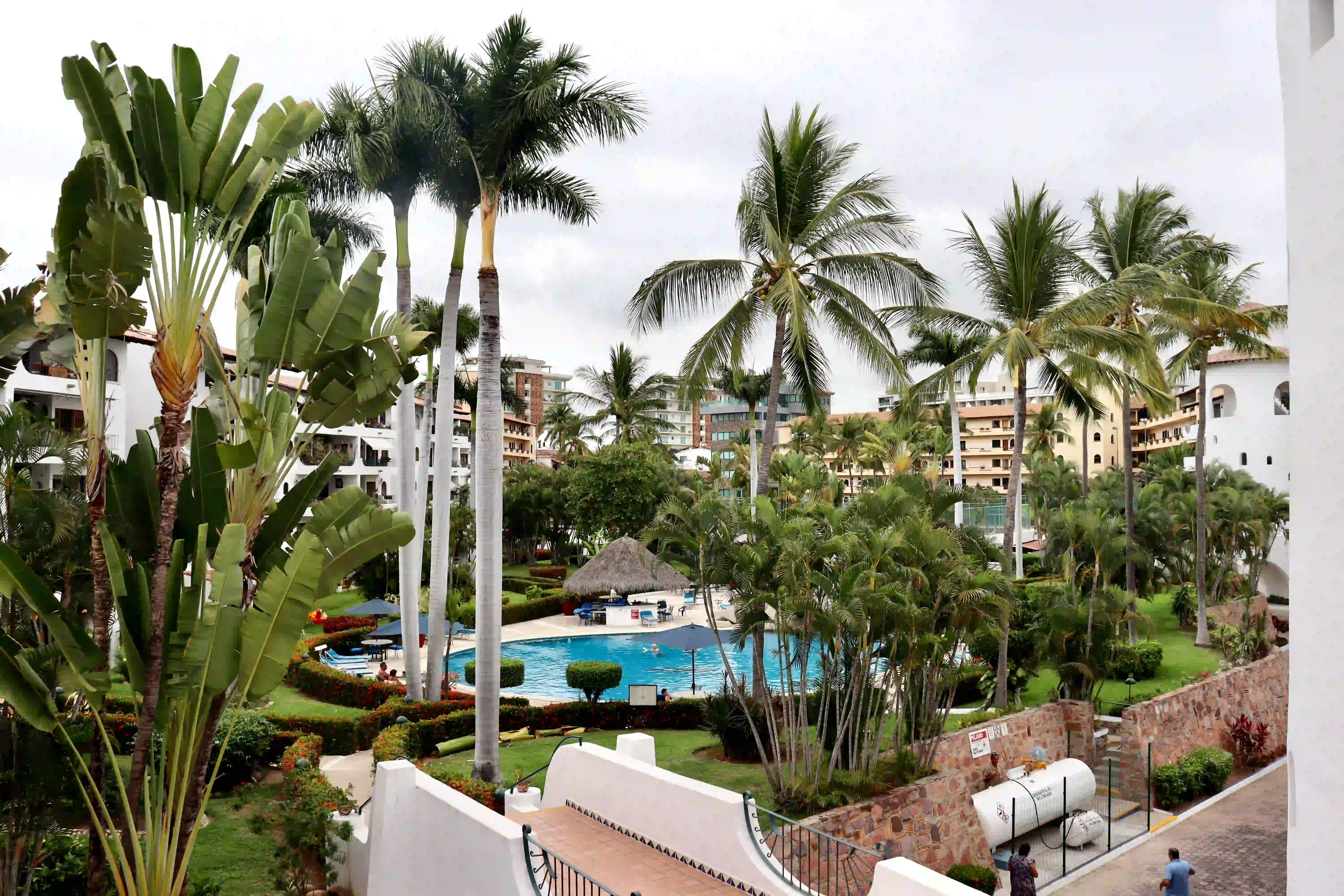 Large resort-style swimming pool at Royal Pacific, surrounded by lush palm trees and tropical landscaping for a serene atmosphere.