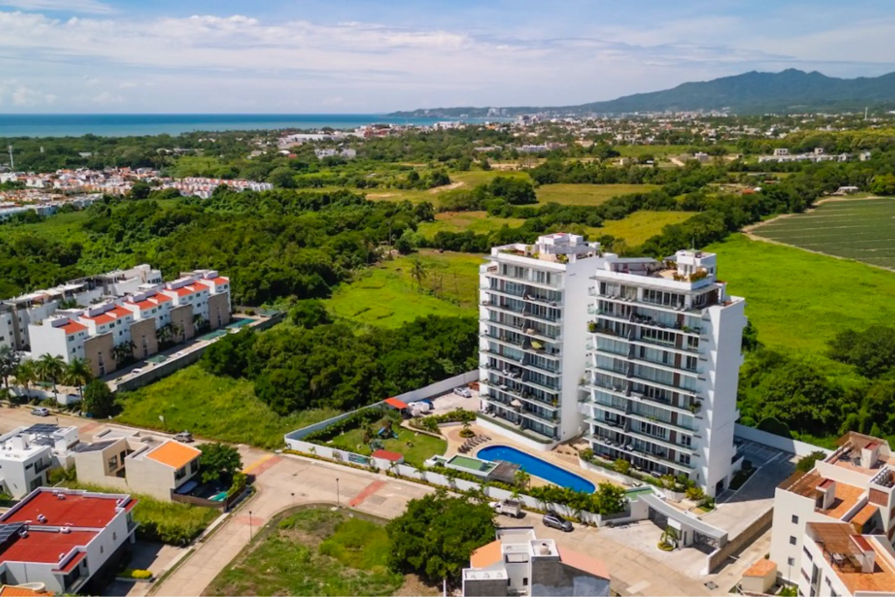 Aerial drone photography of the Believe development in Flamingos, showcasing the modern architectural design, rooftop infinity pool, and its prime location near the Pacific coast.