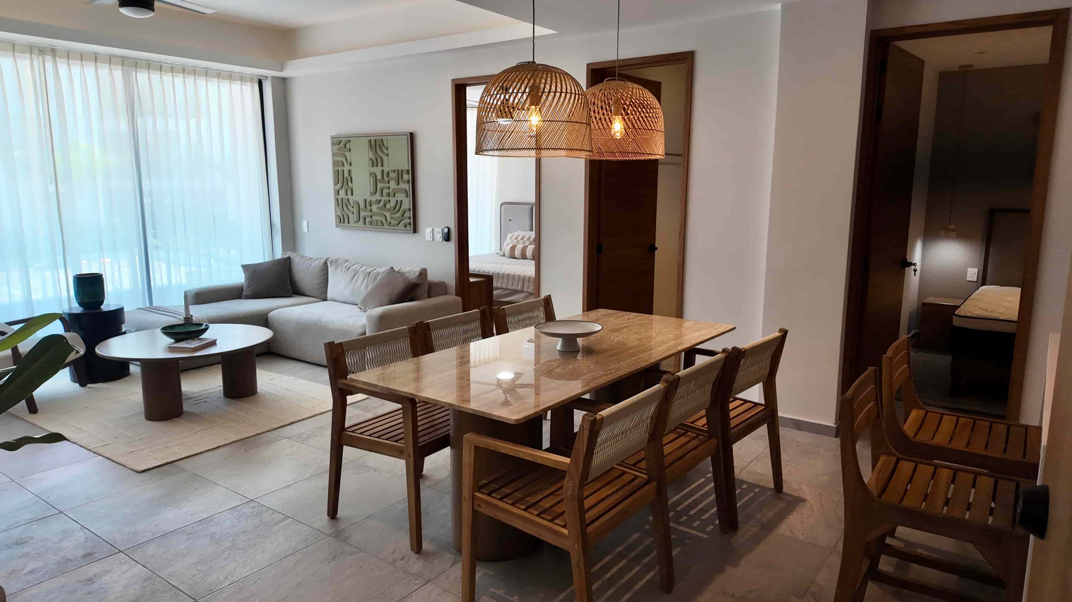 Open-concept living and dining area in the fully furnished TERRA 242 model unit, highlighting modern interior design and warm lighting.