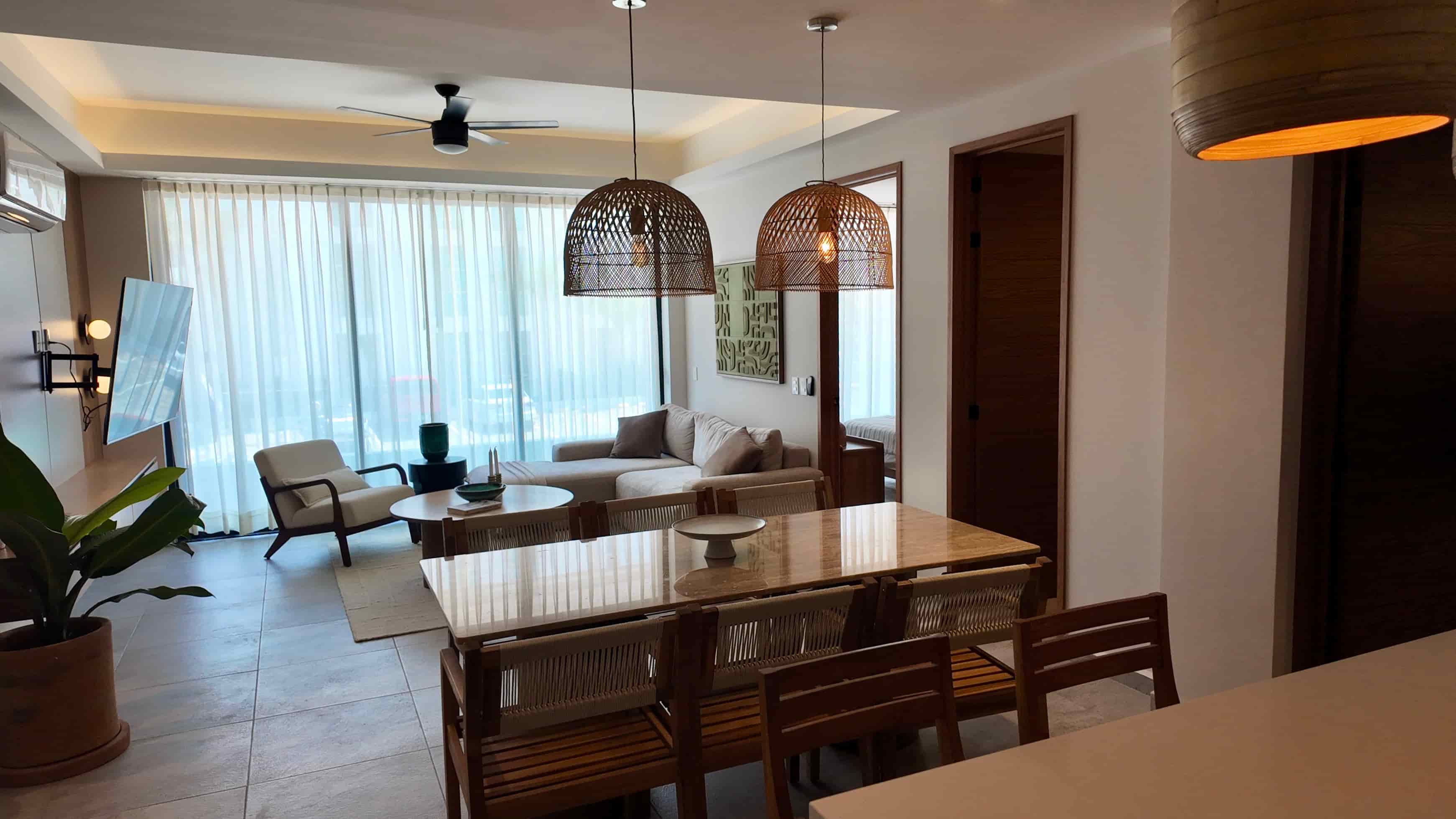 Dining table setup adjacent to large floor-to-ceiling glass doors, letting in ample natural light within the luxury TERRA 242 showroom apartment.