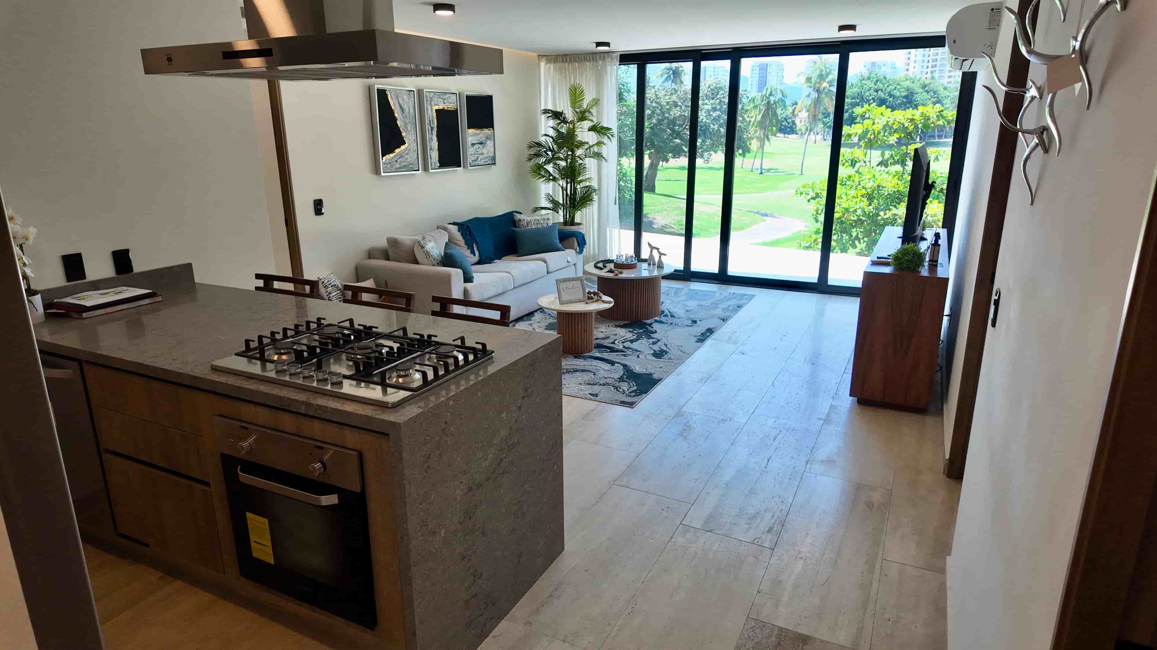Wide view from the social kitchen looking out to the bright living room area, emphasizing an ideal open floor plan for entertaining.