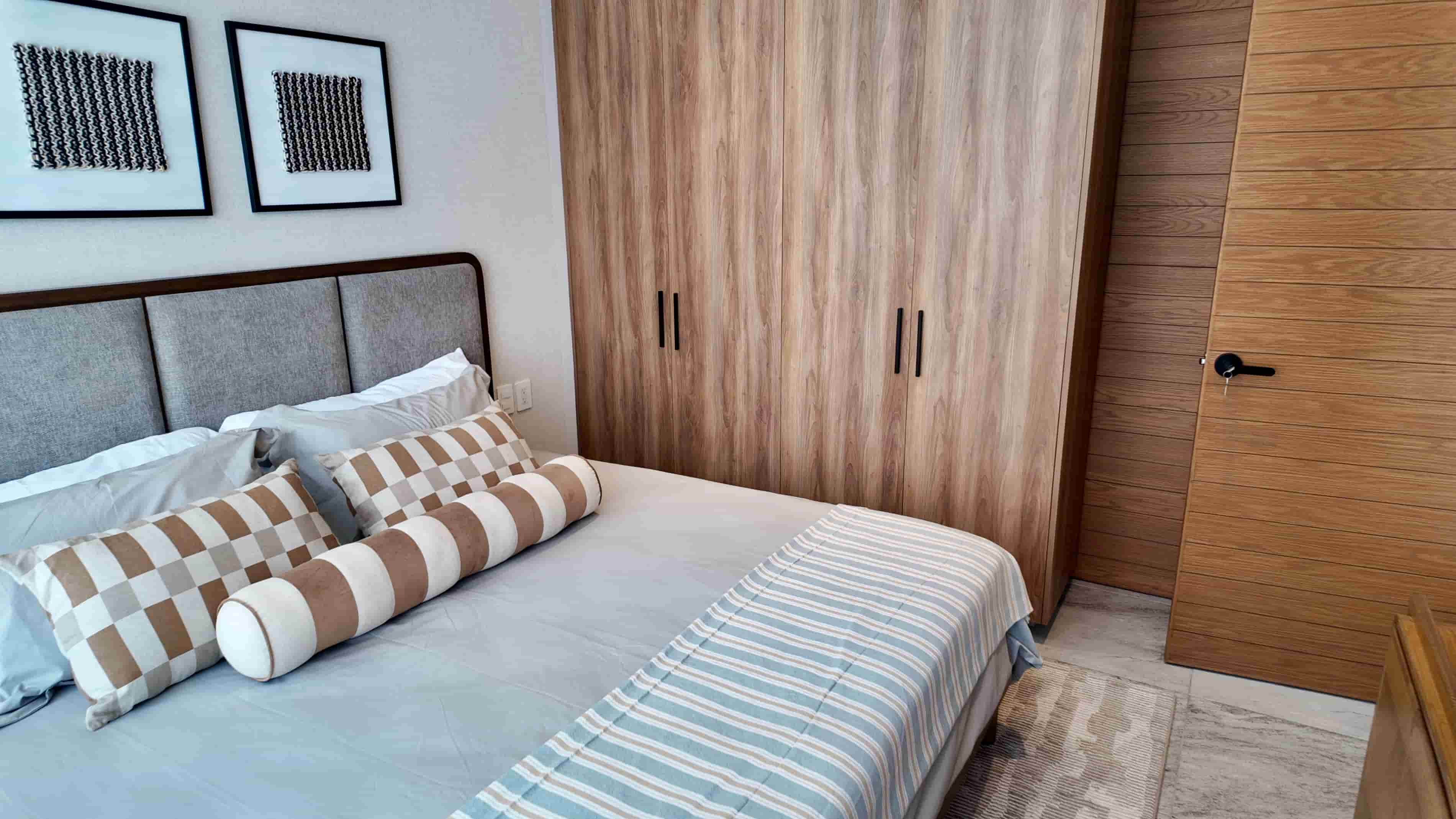 Cozy bedroom layout featuring built-in wooden closets and contemporary light fixtures for an upscale residential feel in TERRA 242.