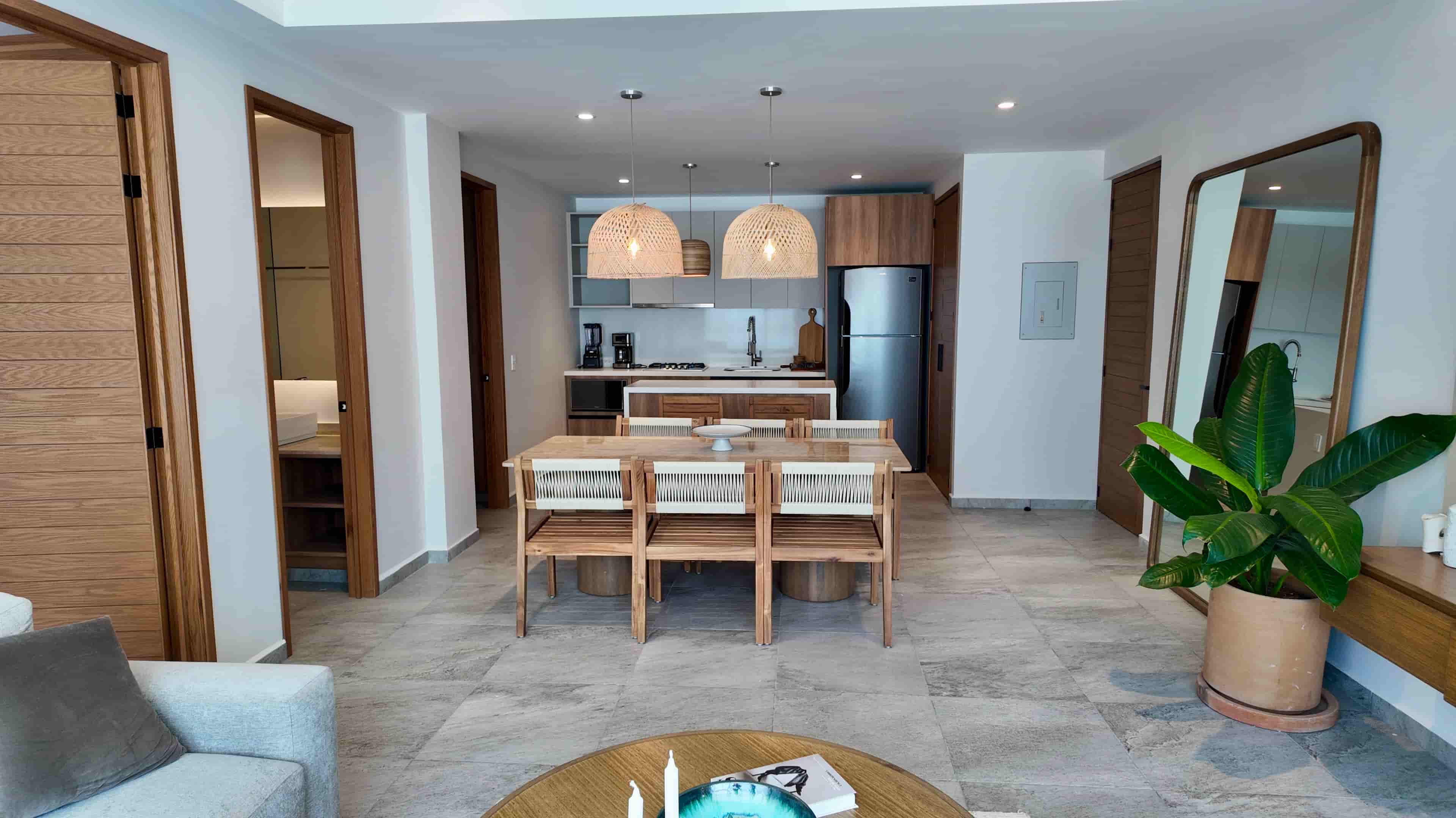 Wide view of the main living space looking toward the entrance, showcasing a complete turn-key condo layout at TERRA 242 in Puerto Vallarta.