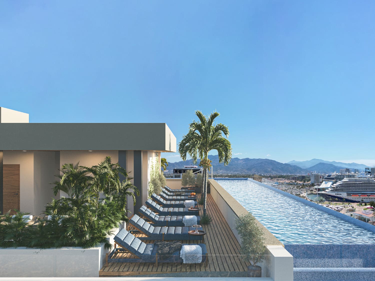 Rooftop infinity pool deck with loungers and panoramic ocean view at DUE Vallarta