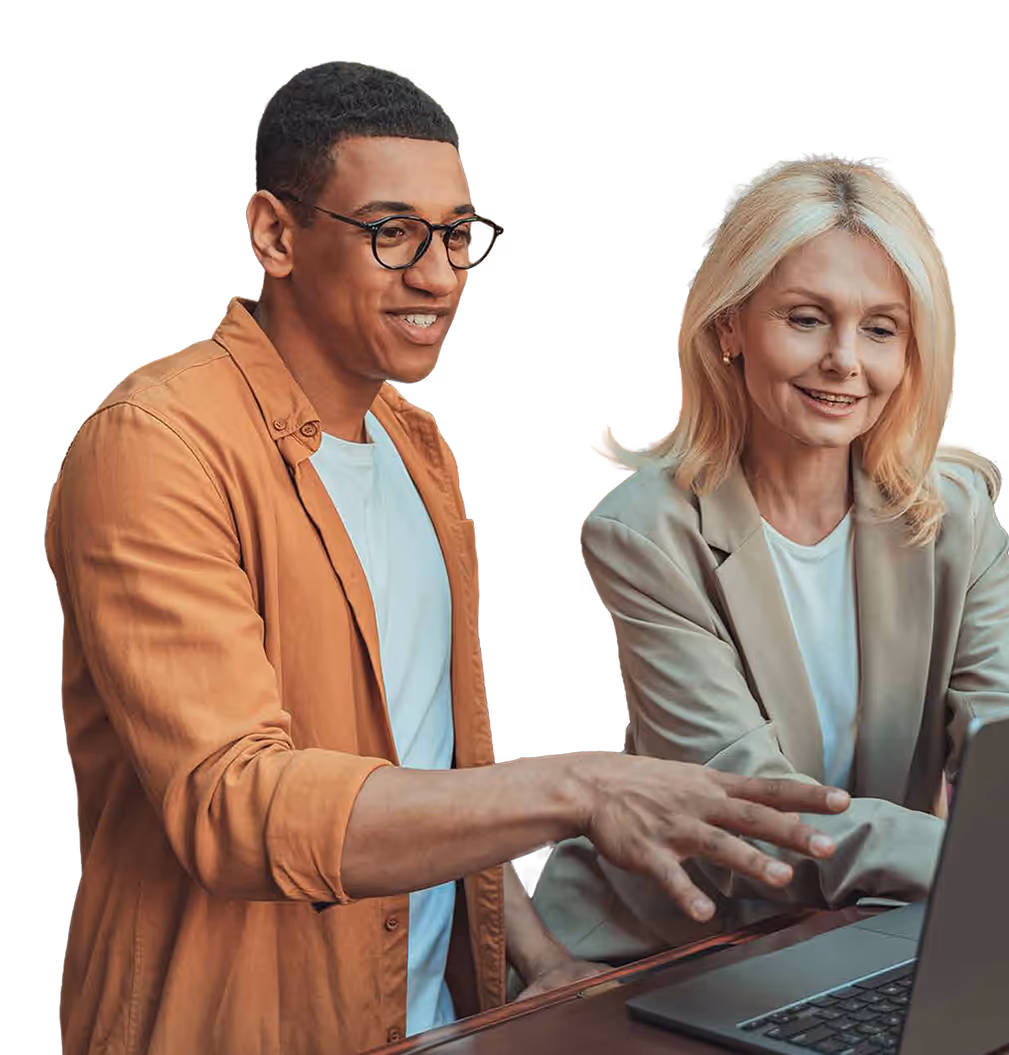 Two colleagues, a man in glasses and a woman with blonde hair, discussing while looking at a laptop screen.
