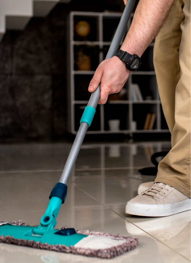 Flat mop cleaning a glossy tile floor to remove salt and ice melt residue