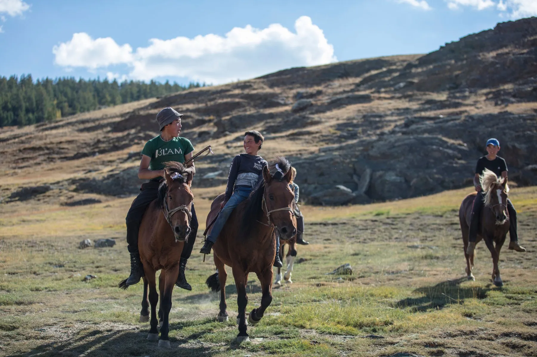 Janibek laughs with his friends before a horse race at the autumn camp. September 2016.