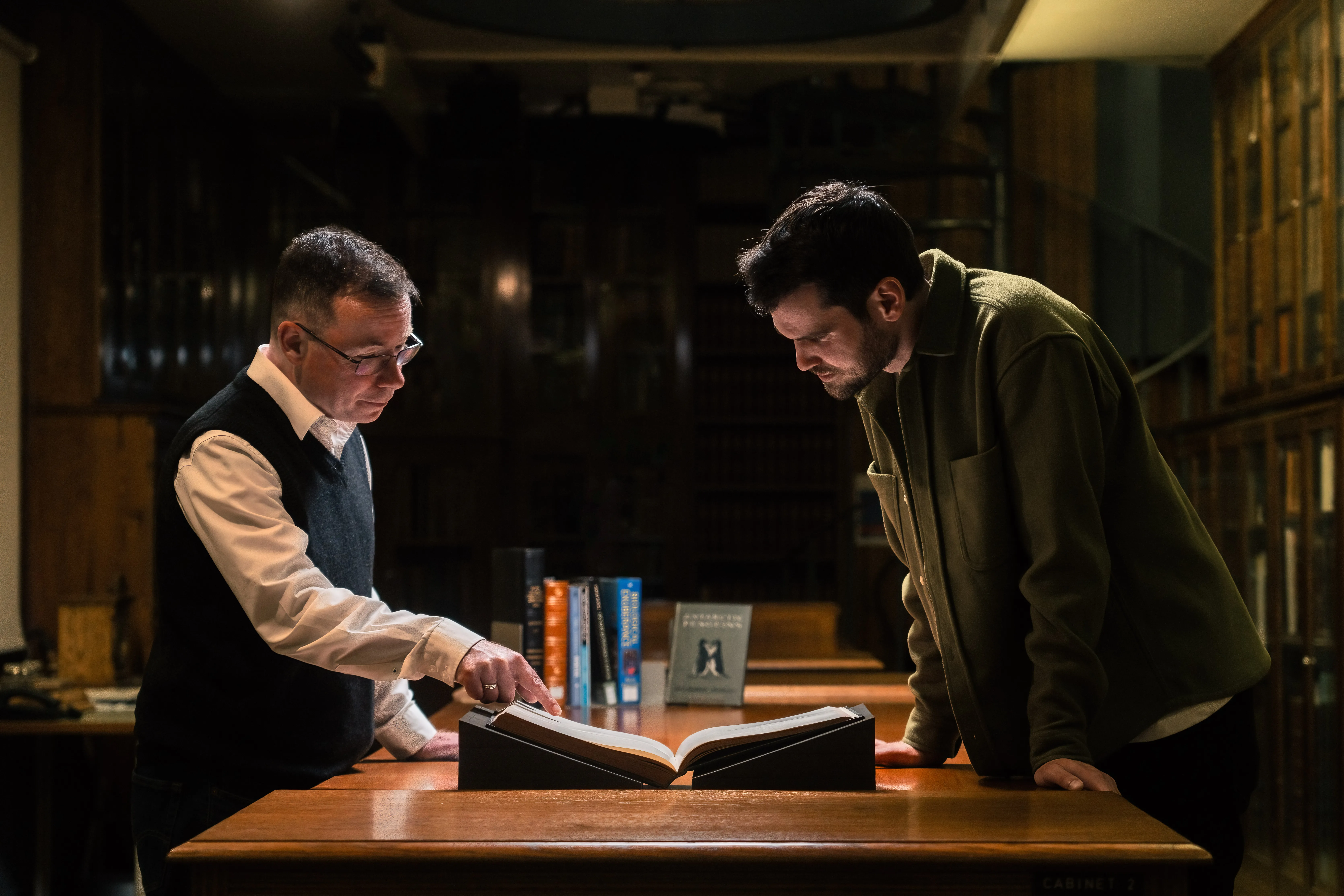 Natural History Museum Curator, Douglas Russel and Connel Bradell examine a research report with held from publication for over 100 years.