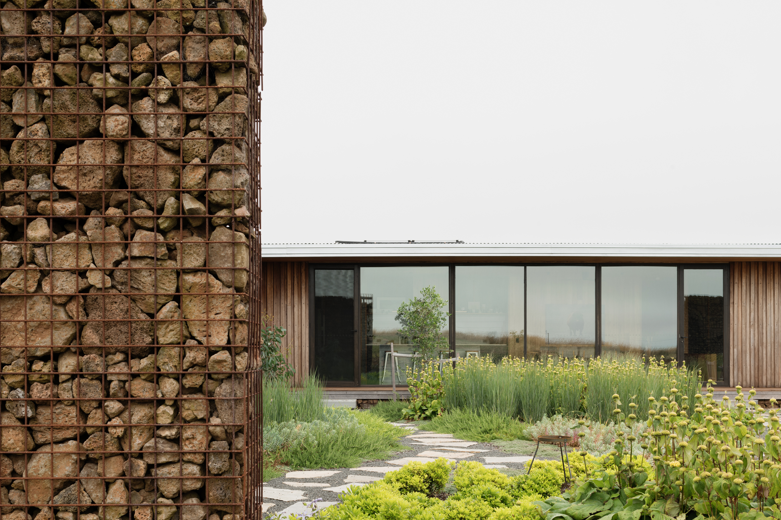 gabion wall sheltering a productive garden and providing separation from farm