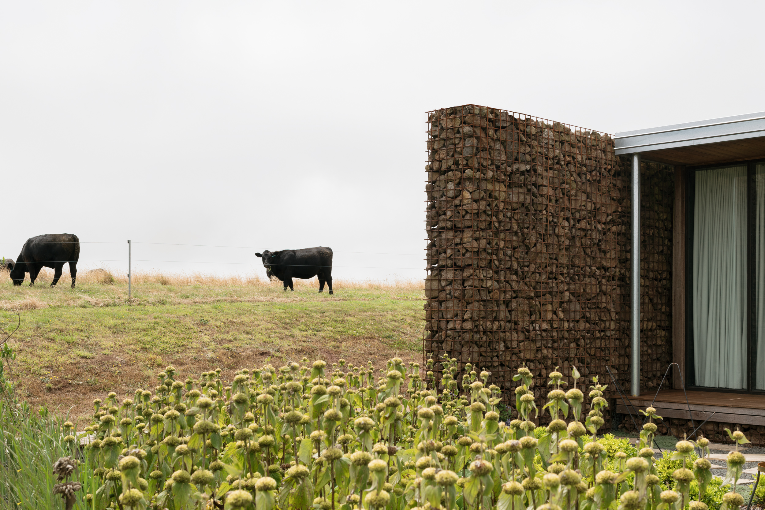 gabion wall sheltering a productive garden and providing separation from farm