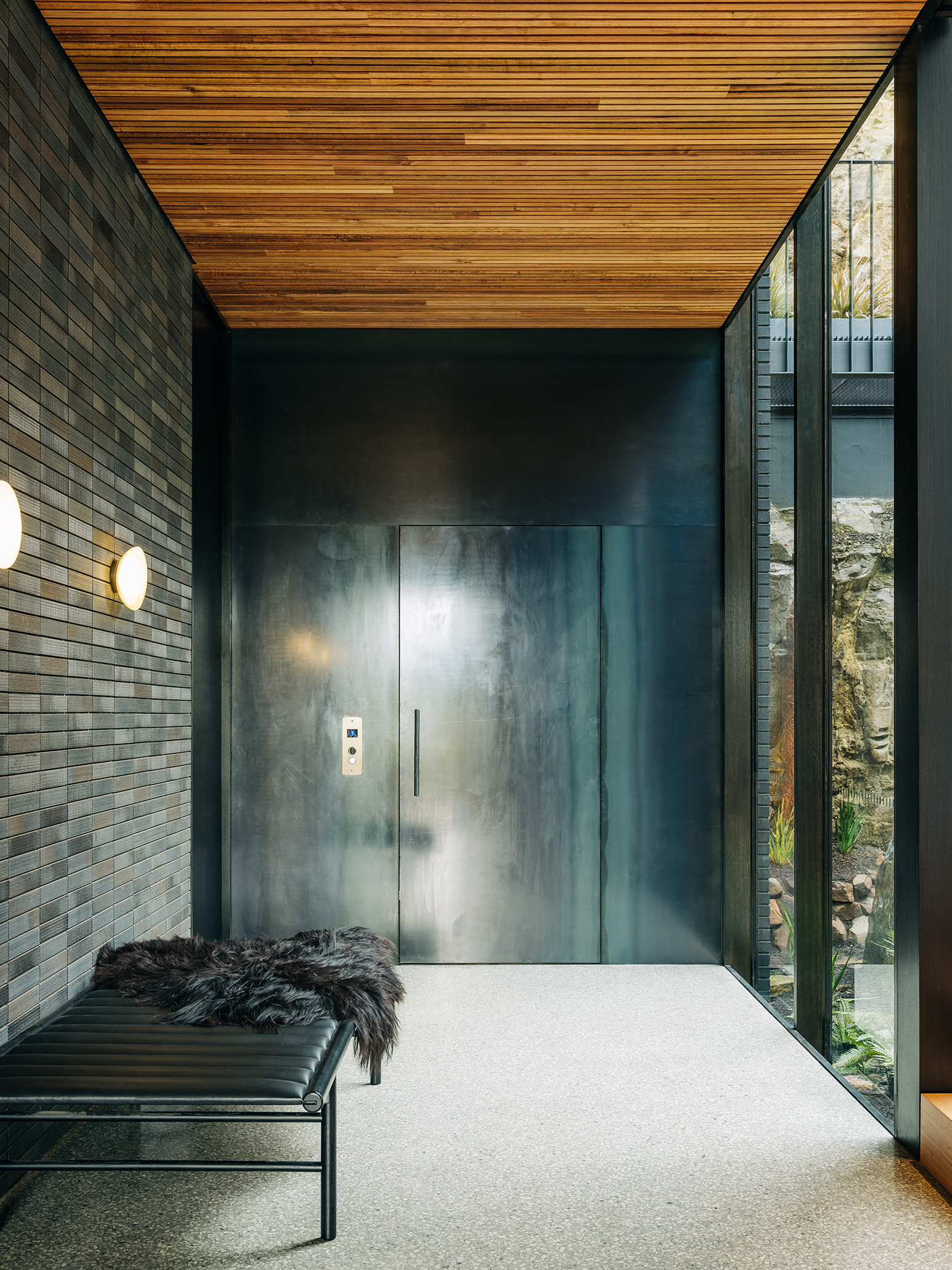 tiled wall, timber ceiling and full height glazing in hallwayin 