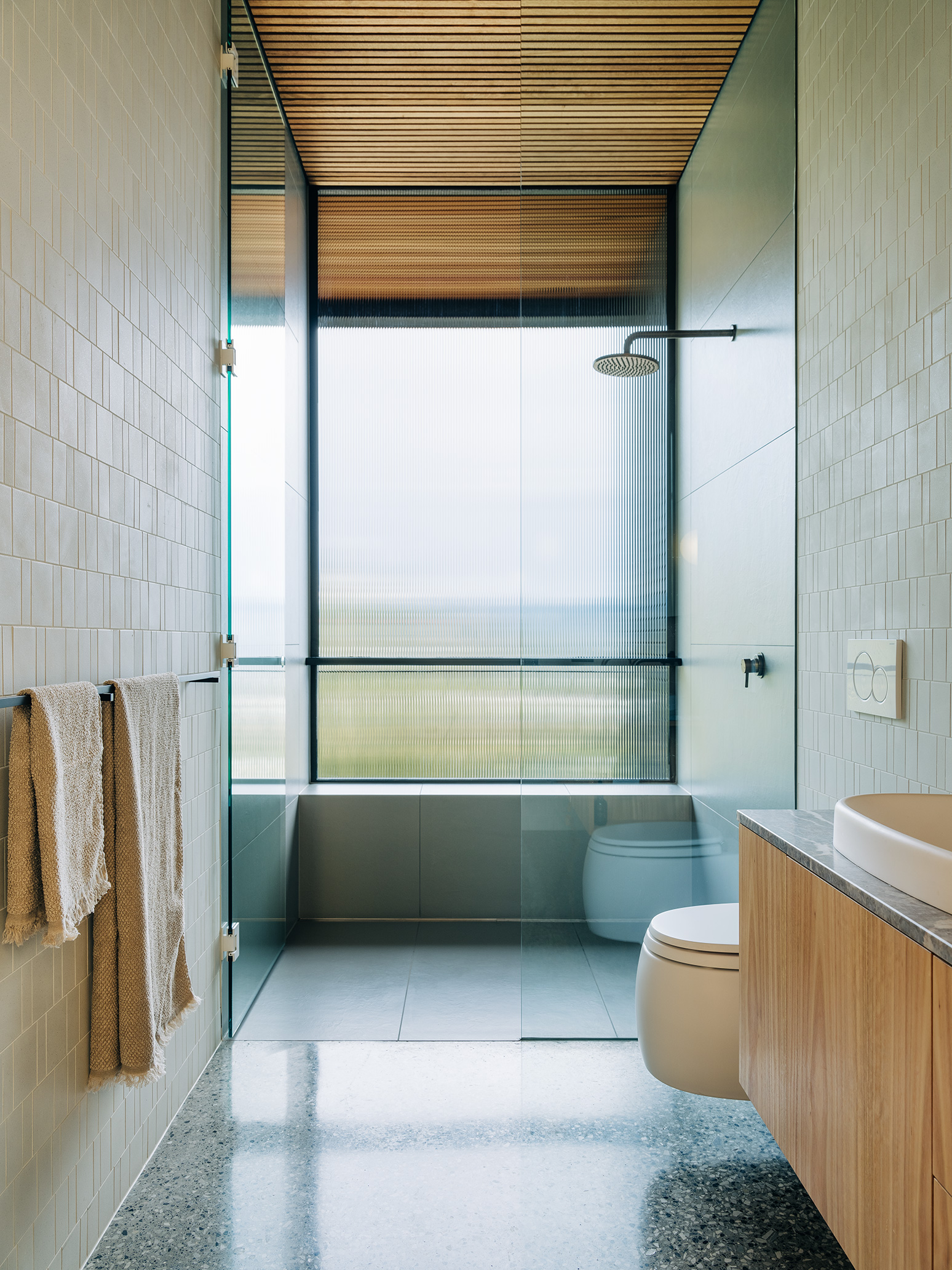 light filled bathroom with floating toilet