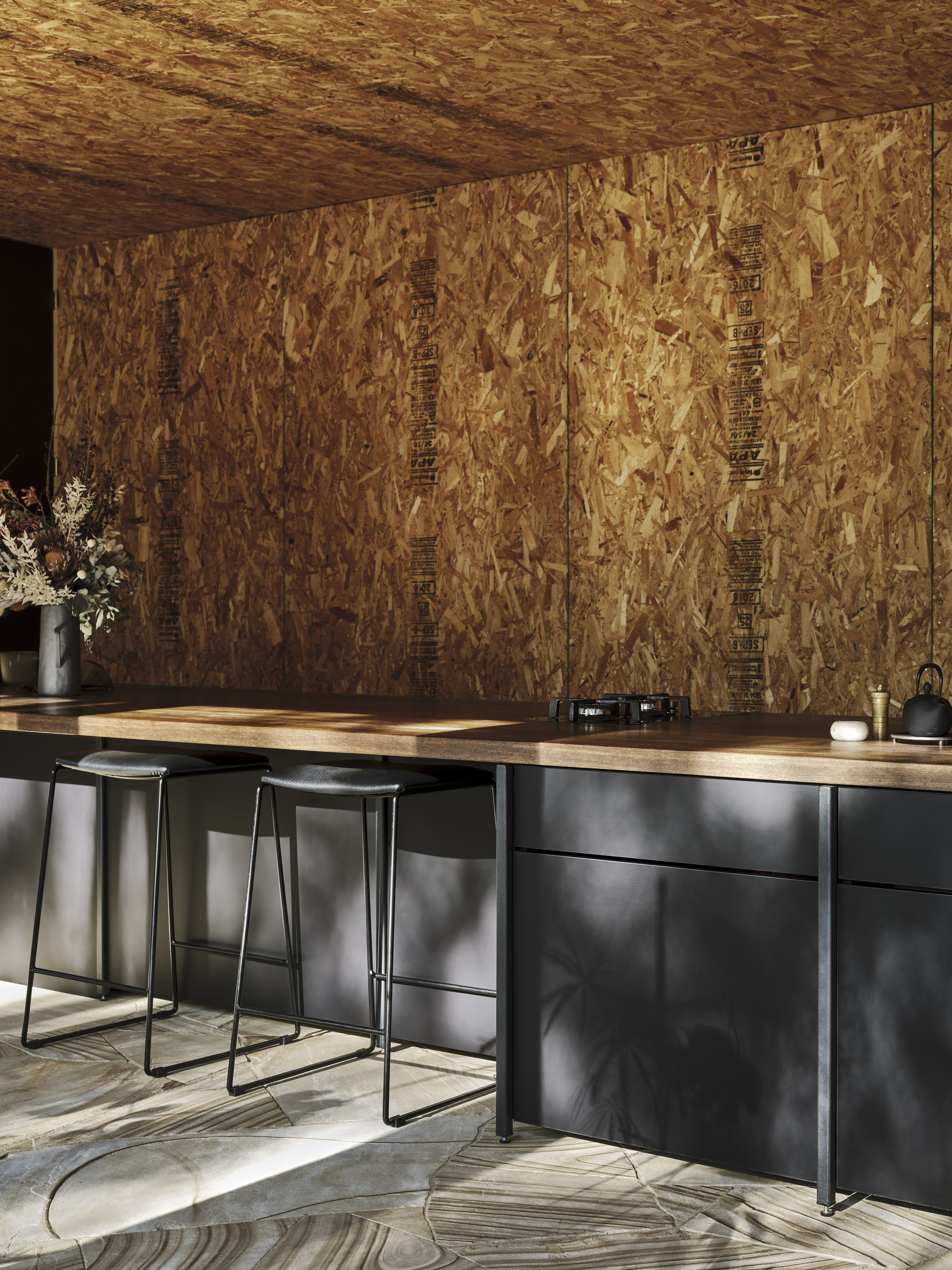 exposed raw timber OSB ceiling with sandstone floor