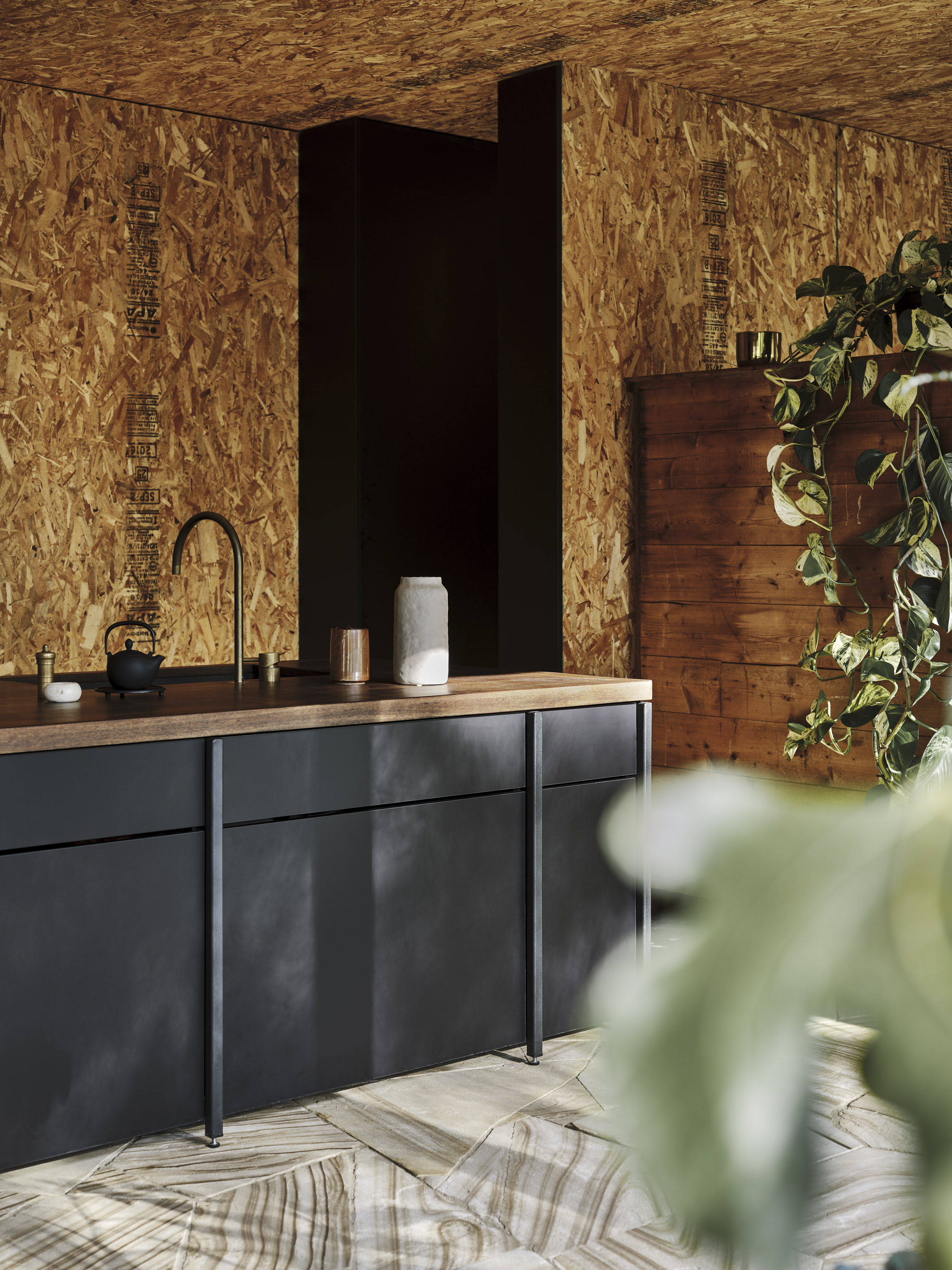 exposed raw timber OSB ceiling with sandstone floor