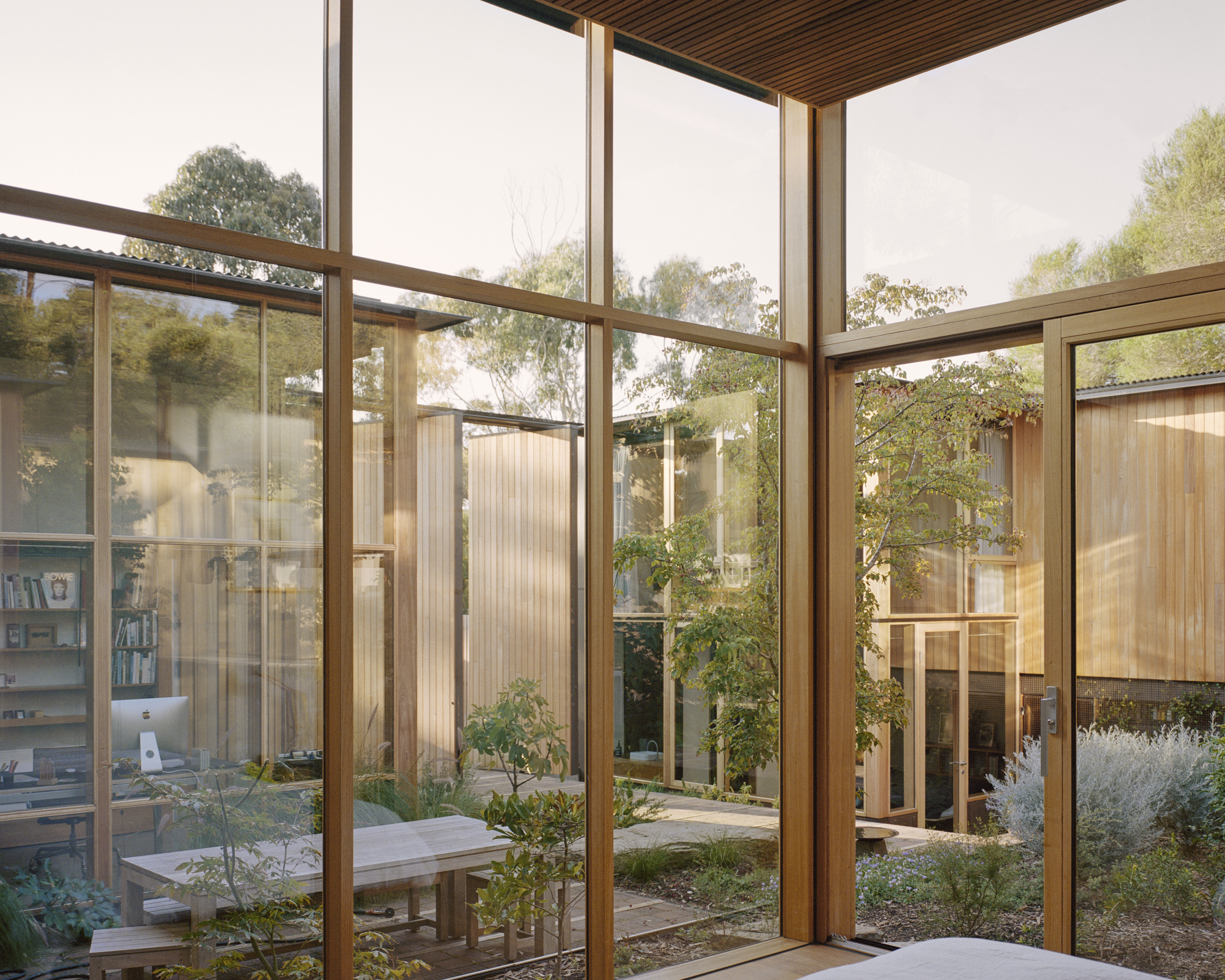 mid century architectural home with high ceilings and full height glazing connecting to garden