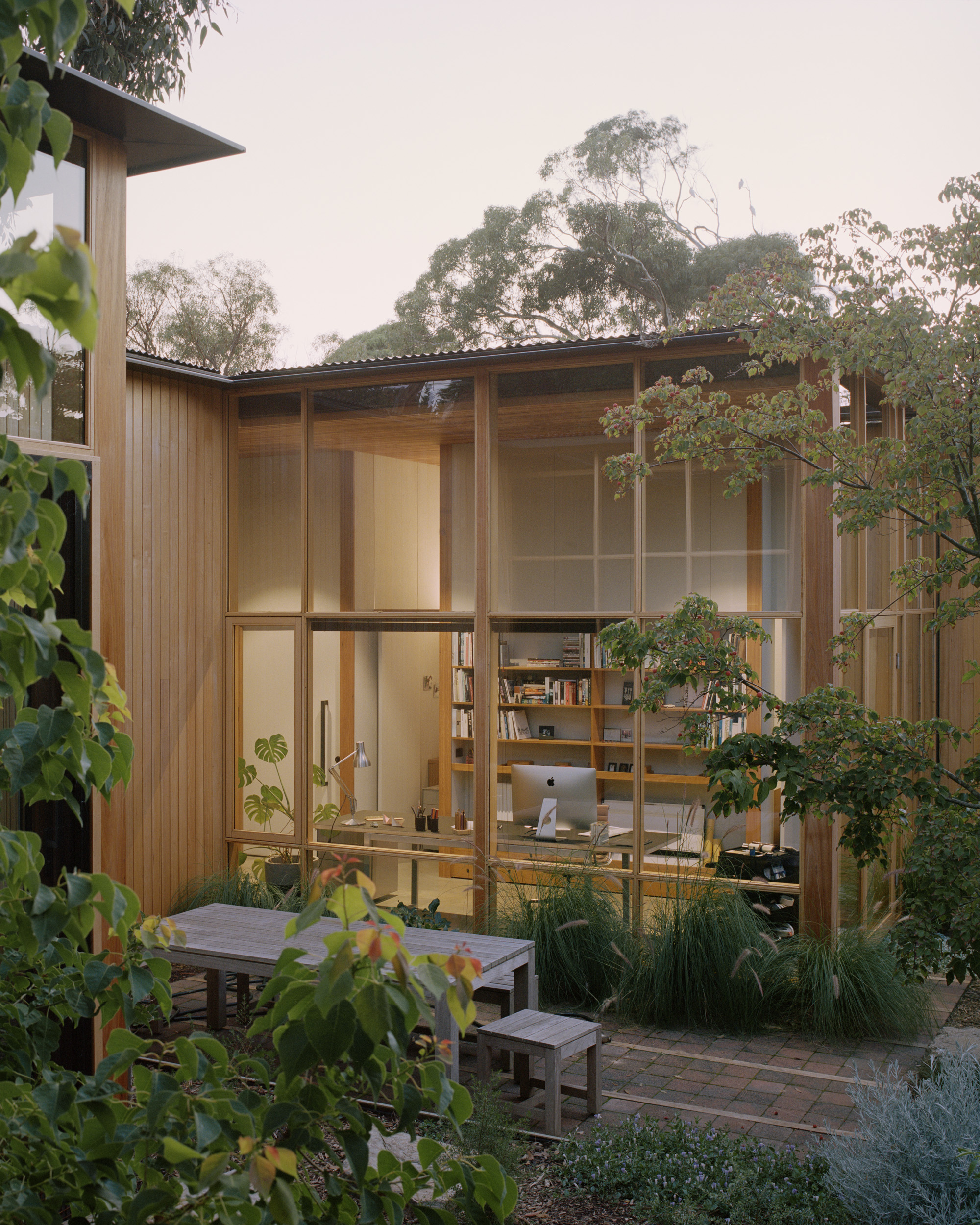 mid century architectural home with high ceilings and full height glazing connecting to garden