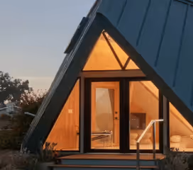 The Tetra ADU's illuminated glass entry at dusk