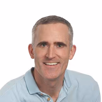 Headshot of Tom smiling in a professional photo