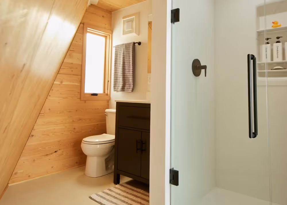 Tetra's bathroom with wood-paneled walls, vanity, and glass shower enclosure