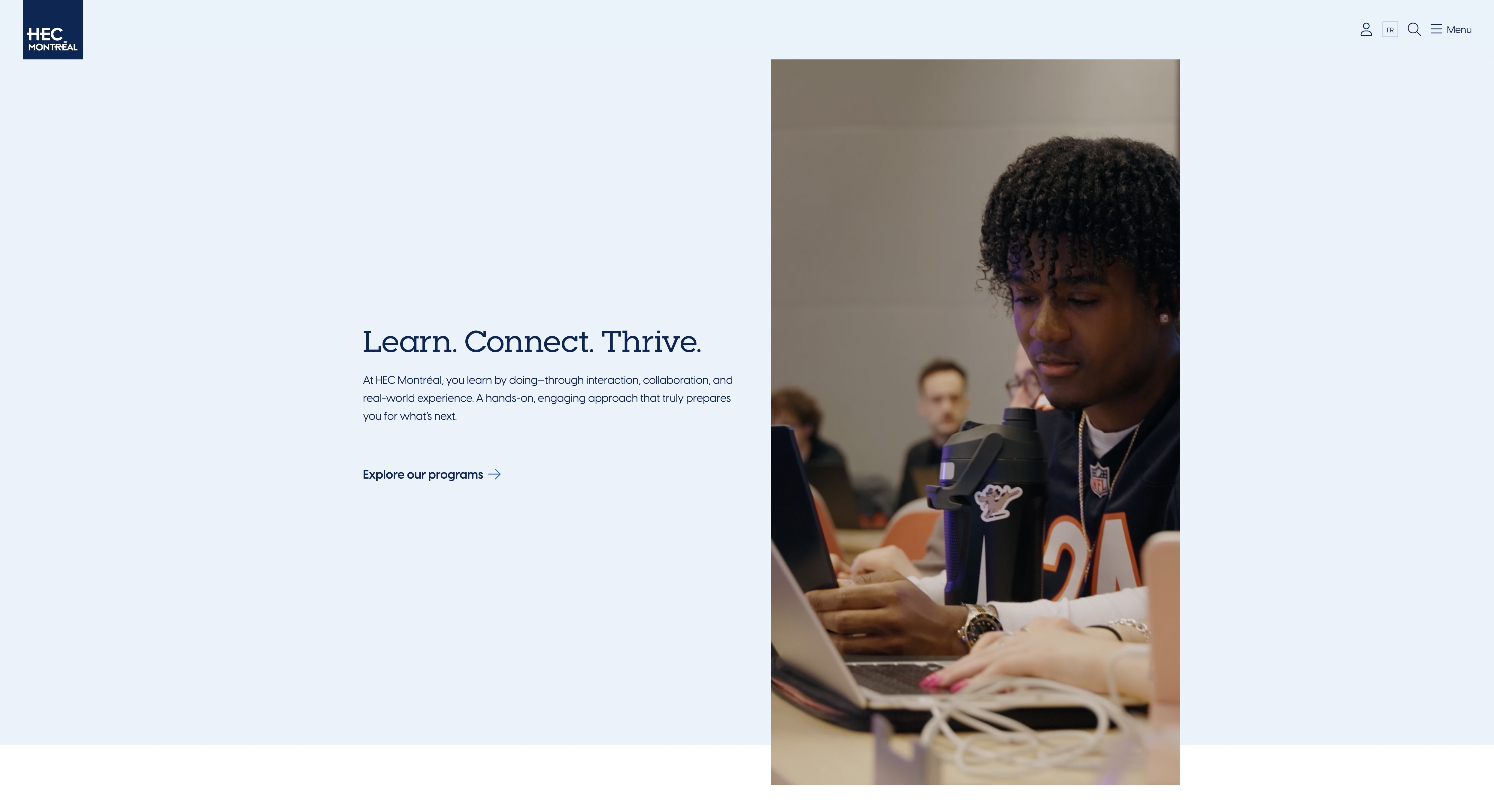 HEC Montréal homepage: full-bleed photography with minimal navy-on-pale-blue chrome, one idea per band.