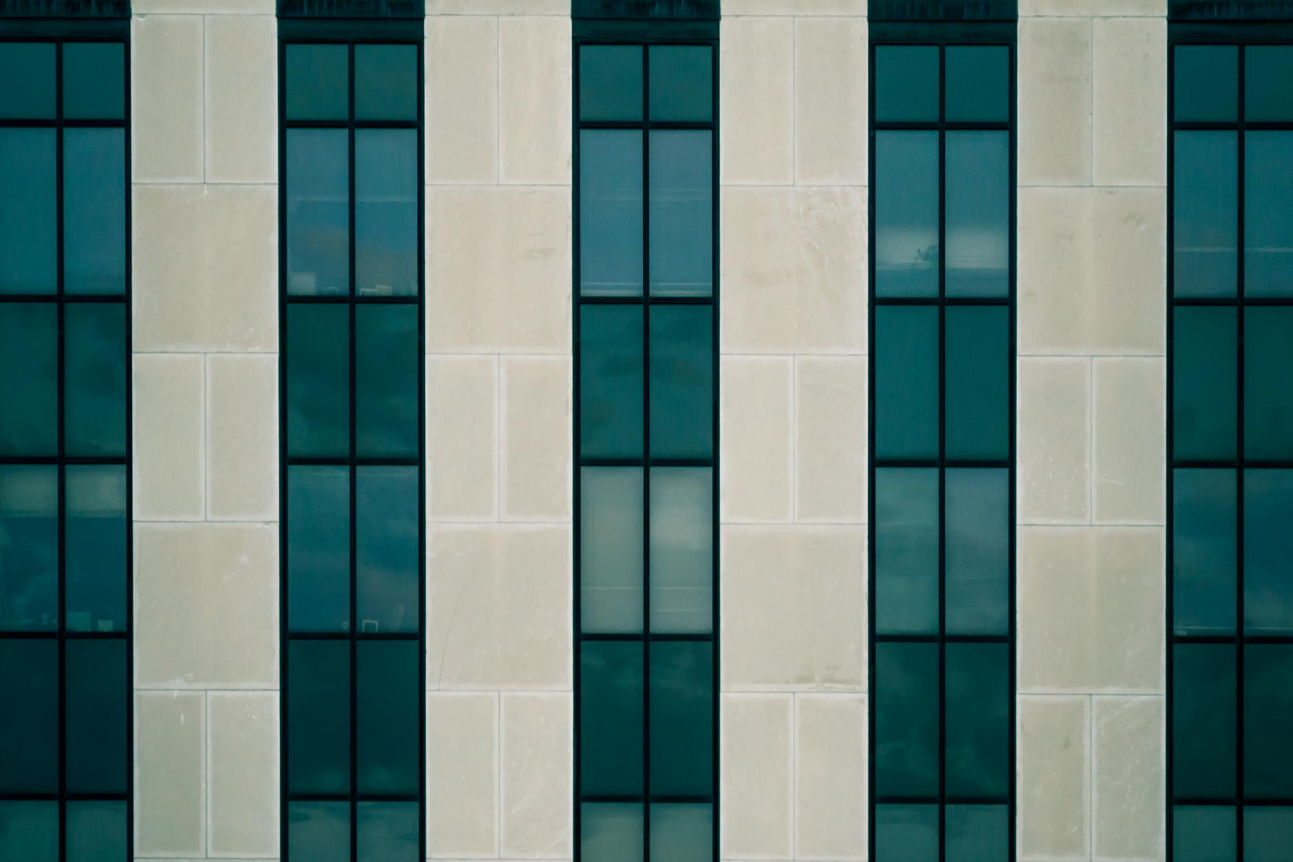 Symmetrical facade of a modern building showcasing glass and concrete patterns.