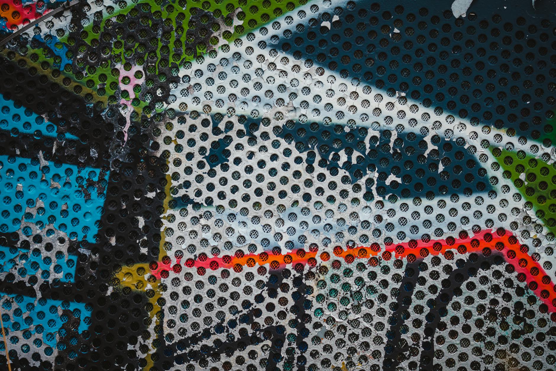 Colorful abstract graffiti with texture on perforated metal in Ostrava, Czechia.