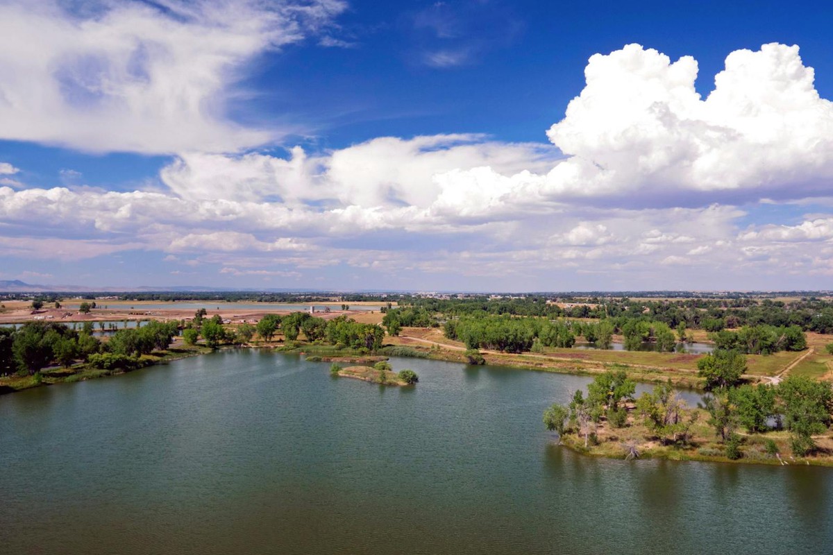 Scenic aerial view of a serene lake surrounded by lush greenery in Fort Collins, Colorado.