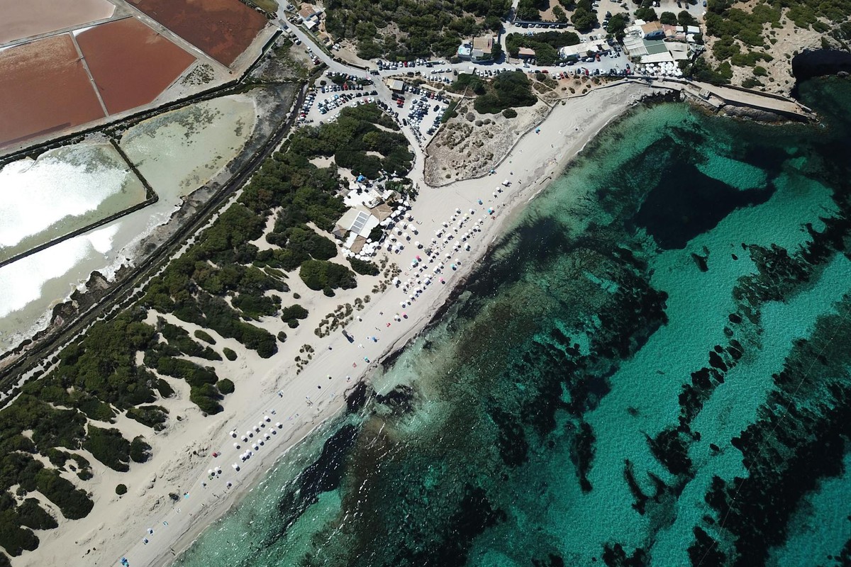 Drone view of Salinas Beach, showing clear waters and salt flats in sunny Spain.