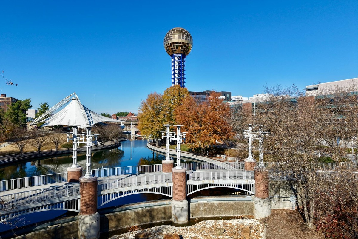 A vibrant aerial view of the iconic Sunsphere amidst fall foliage in Knoxville, Tennessee.
