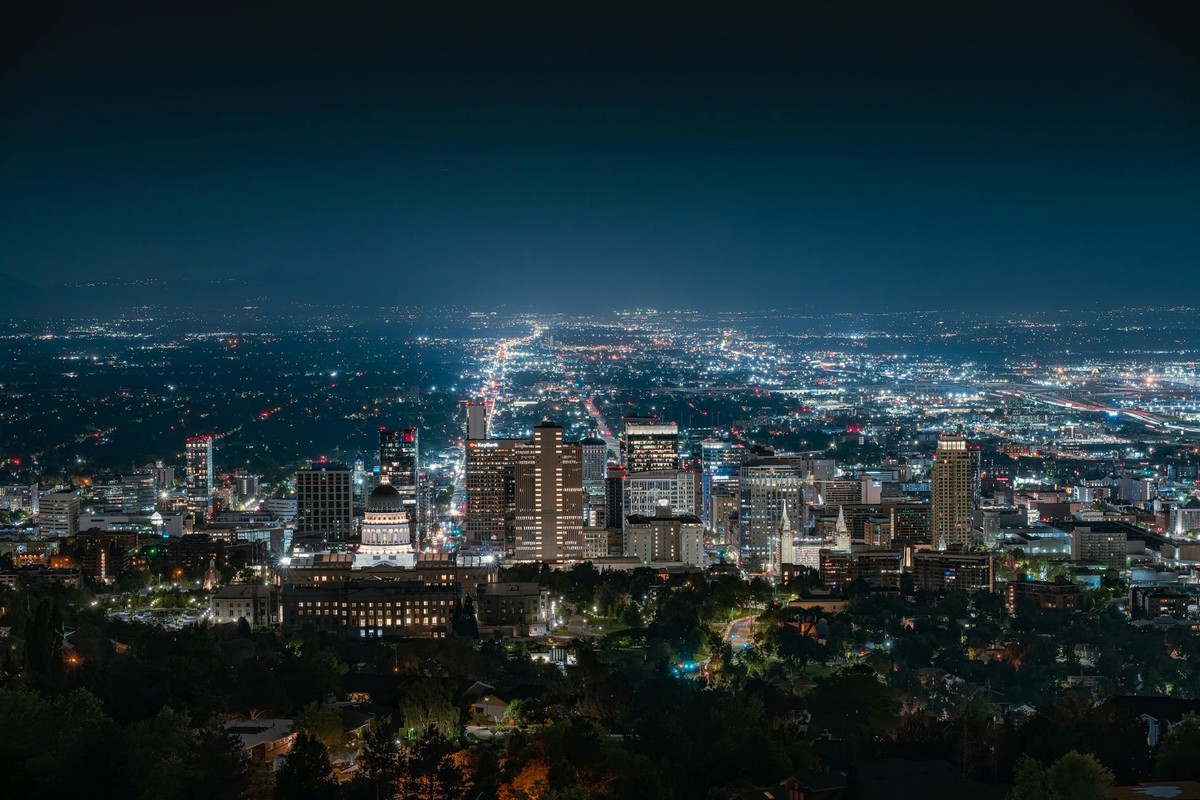 Beautiful nighttime aerial shot of Salt Lake City skyline with illuminated city lights and clear sky.