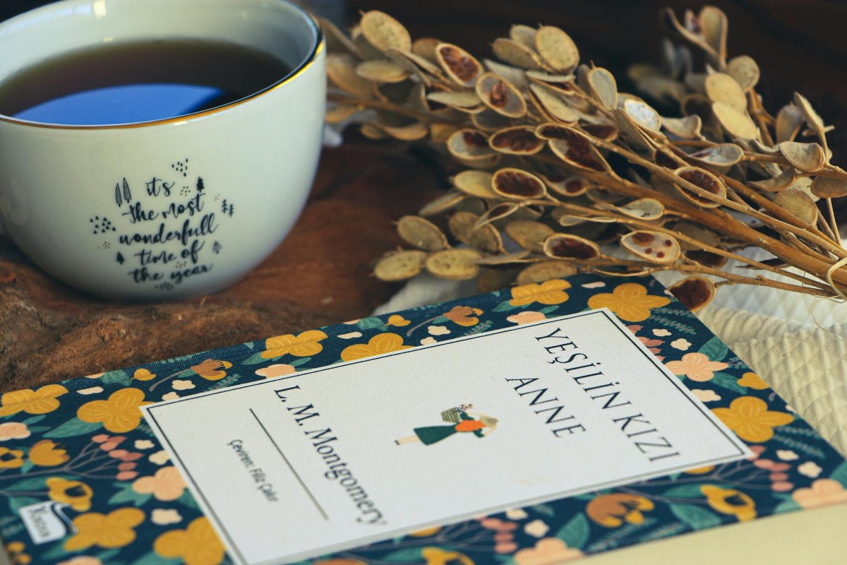 A warm, inviting scene with a floral book and tea on a rustic table.