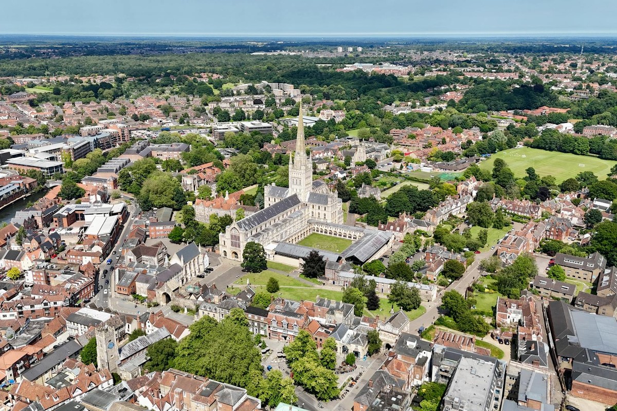 Aerial shot of Norwich Cathedral in Norfolk, showcasing urban and natural landscapes.