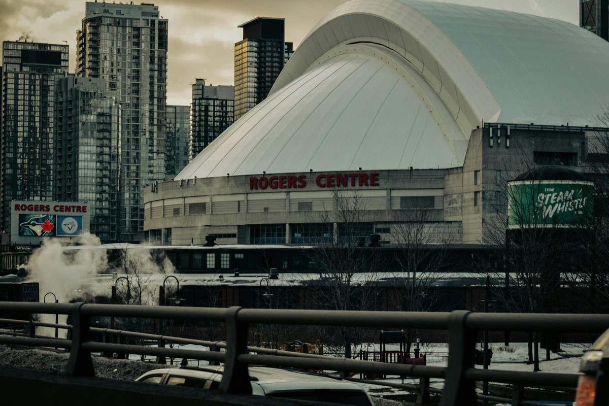Dramatic view of Toronto's Rogers Centre with cityscape backdrop in winter.