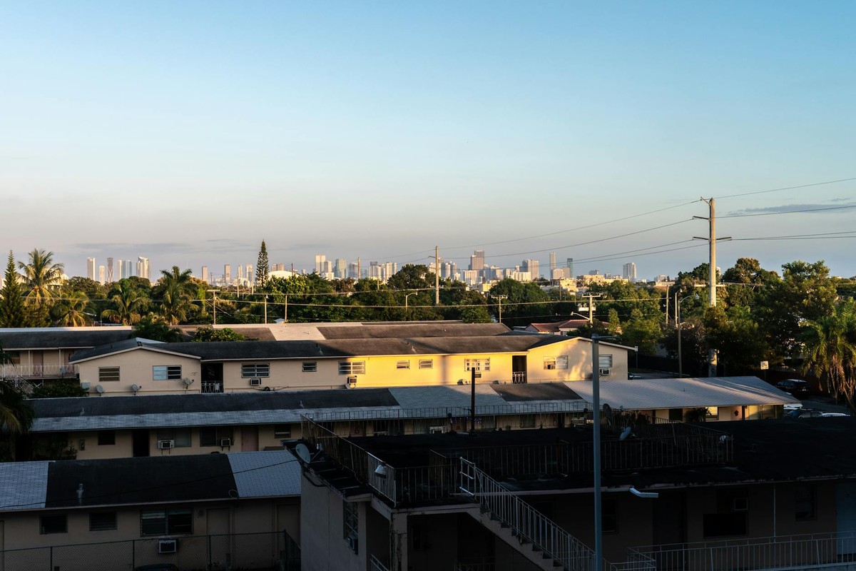 View of Miami skyline from Coral Gables at sunset with residential buildings in foreground.