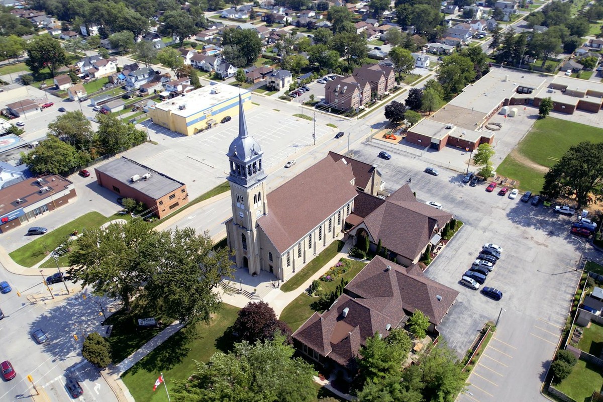 Aerial shot of a church with a spire in a suburban townscape.