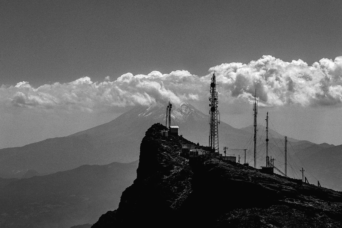 Explore the rugged beauty of Perote, Veracruz with antennas atop a mountain against a cloudy sky.
