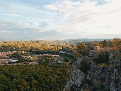 Breathtaking aerial view of Hamden's cliffside overlooking lush forests and distant town.