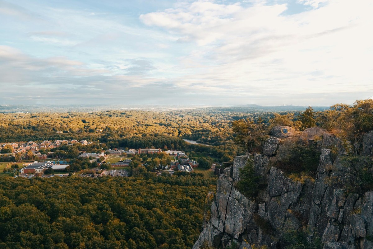 Breathtaking aerial view of Hamden's cliffside overlooking lush forests and distant town.