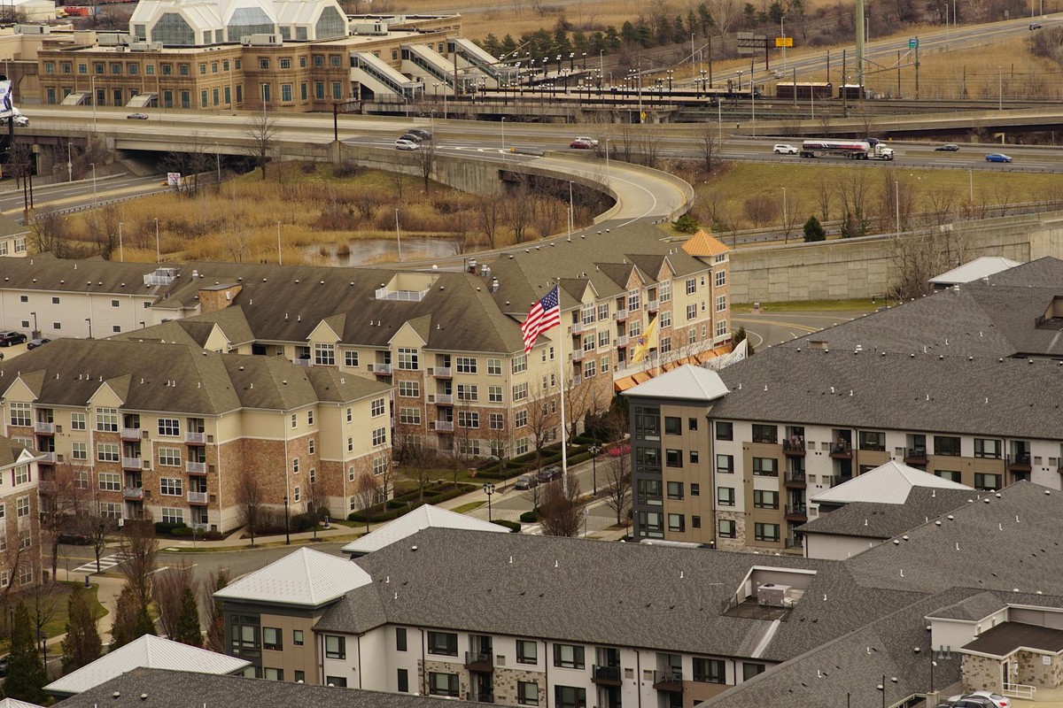 Aerial view of urban residential apartments featuring an American flag, depicting city life.